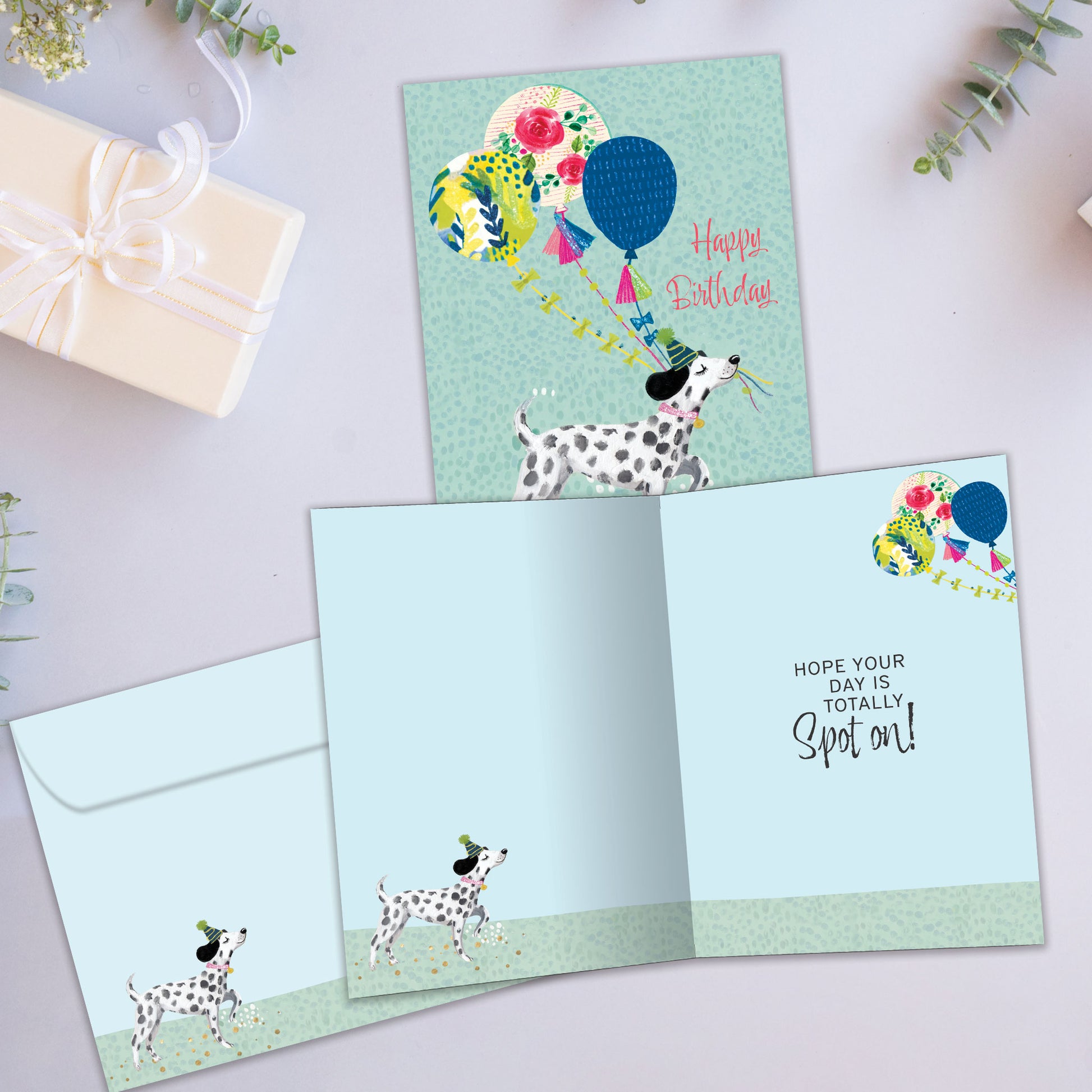 Front and inside view of a Birthday greeting card showcasing a happy dog carrying balloons and the message "Happy Birthday", with a matching envelope