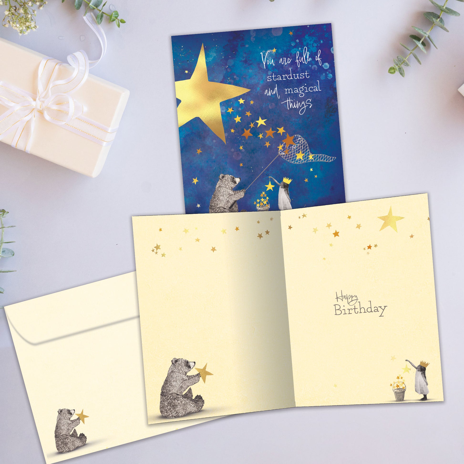 Front and inside view of a Birthday greeting card showcasing a bear catching stars with a sweet message, with a matching envelope.
