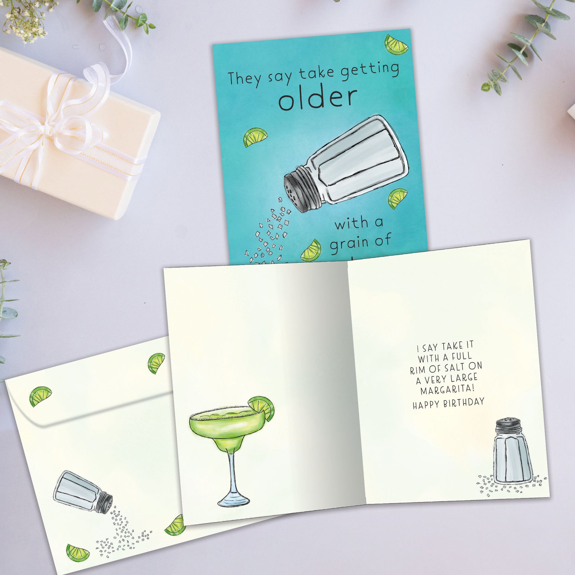 Front and inside view of a Birthday greeting card showcasing a salt shaker and a message about getting older, with a matching envelope