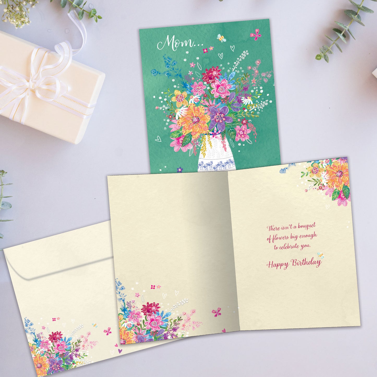 Front and inside view of a Birthday greeting card showcasing an illustration of a vase of flowers and the message "Mom", with a matching envelope