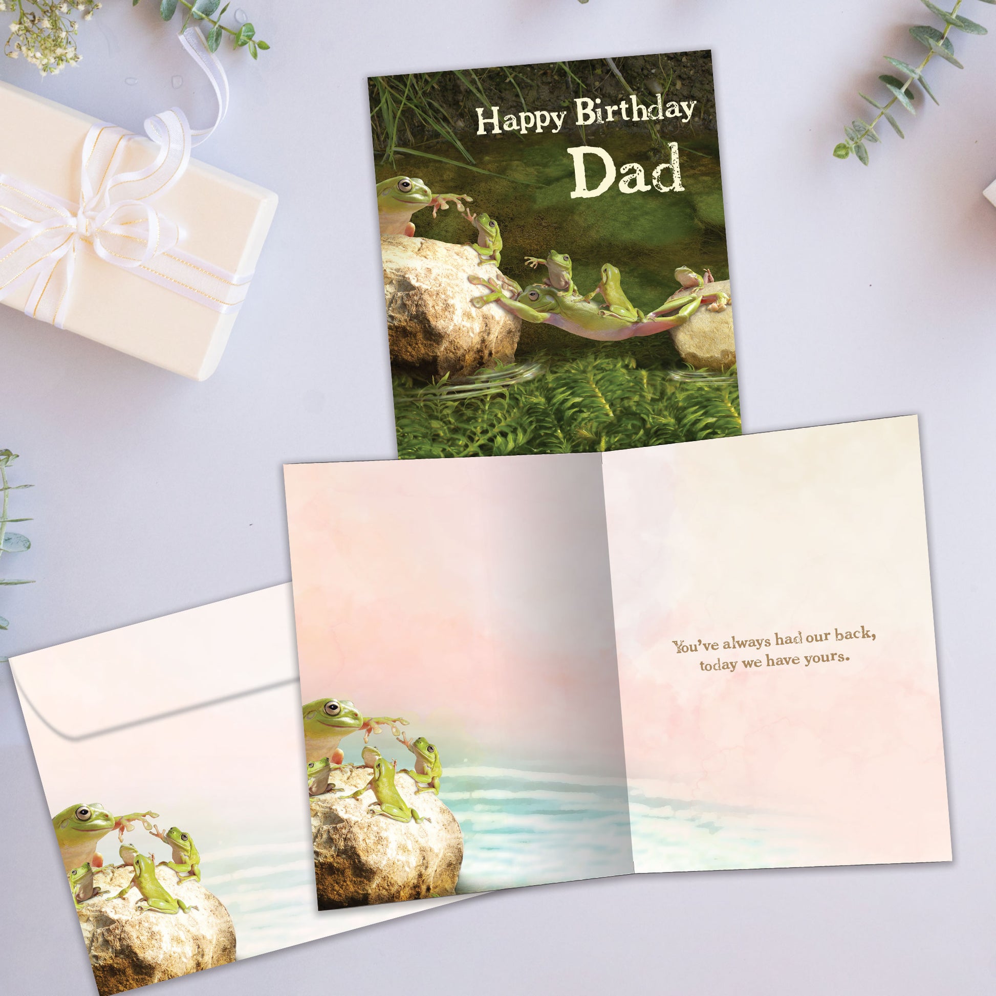 Front and inside view of a Birthday greeting card with a frog dad supporting his children and the words "Happy Birthday Dad", with a matching envelope