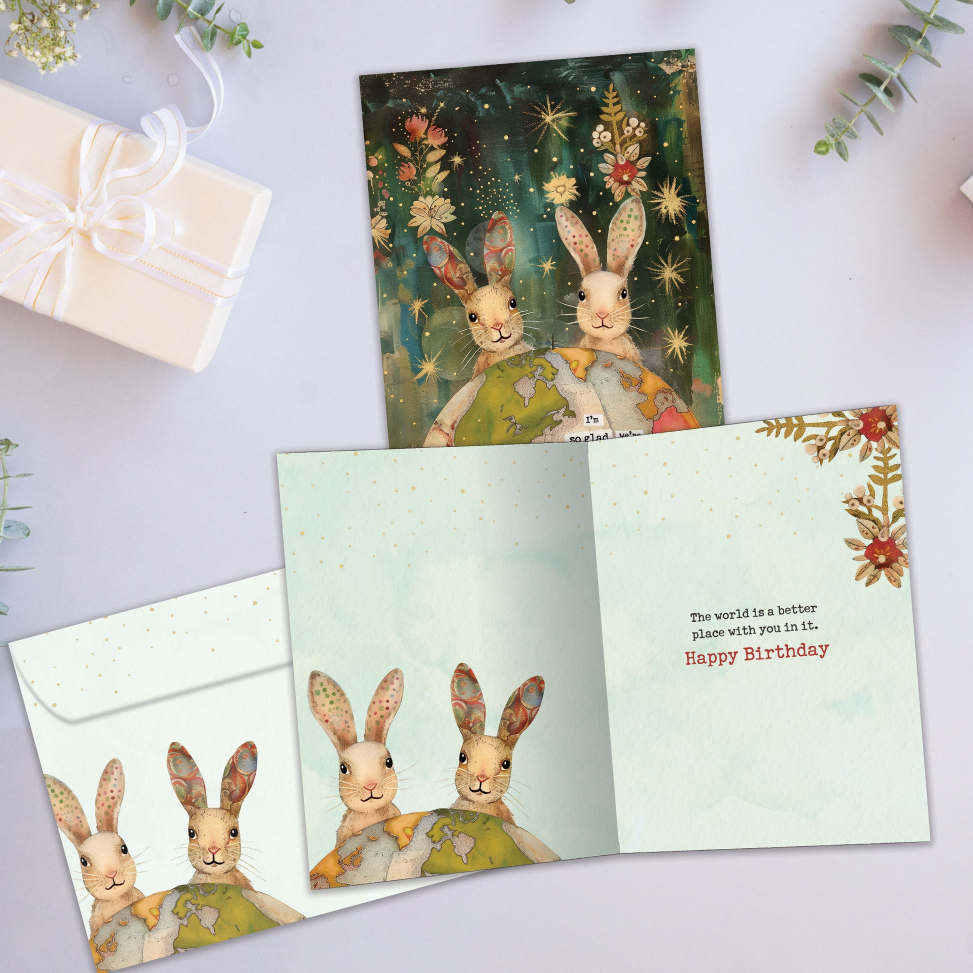 Front and inside view of a Birthday greeting card featuring a two rabbits behind a colourful globe with an endearing message, with a matching envelope