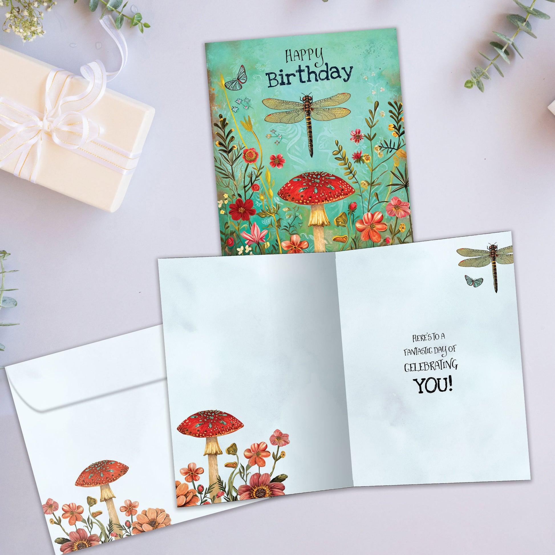 Front and inside view of a Birthday greeting card featuring a whimsical floral with the message "Happy Birthday", with a matching envelope.