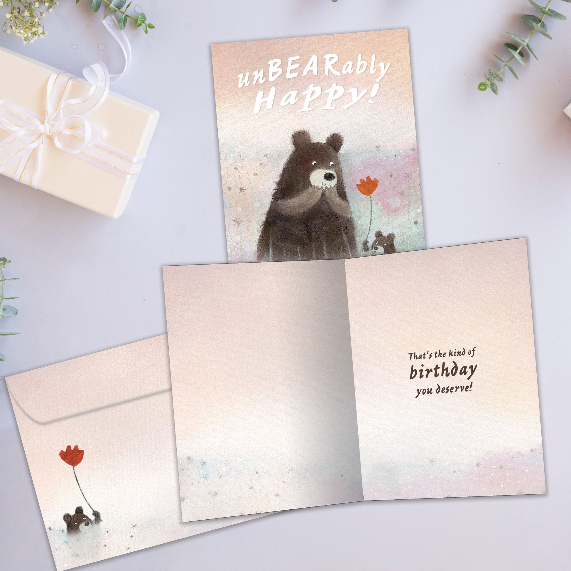 Front and inside view of a Birthday greeting card showcasing an illustration of a cub bear handing a flower to a bear, with a matching envelope.
