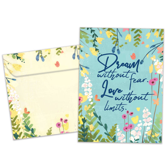 Front view of an All Occasion greeting card and matching envelope featuring the message 'Dream without fear. Love without limits.' on a light blue background with colourful flowers.