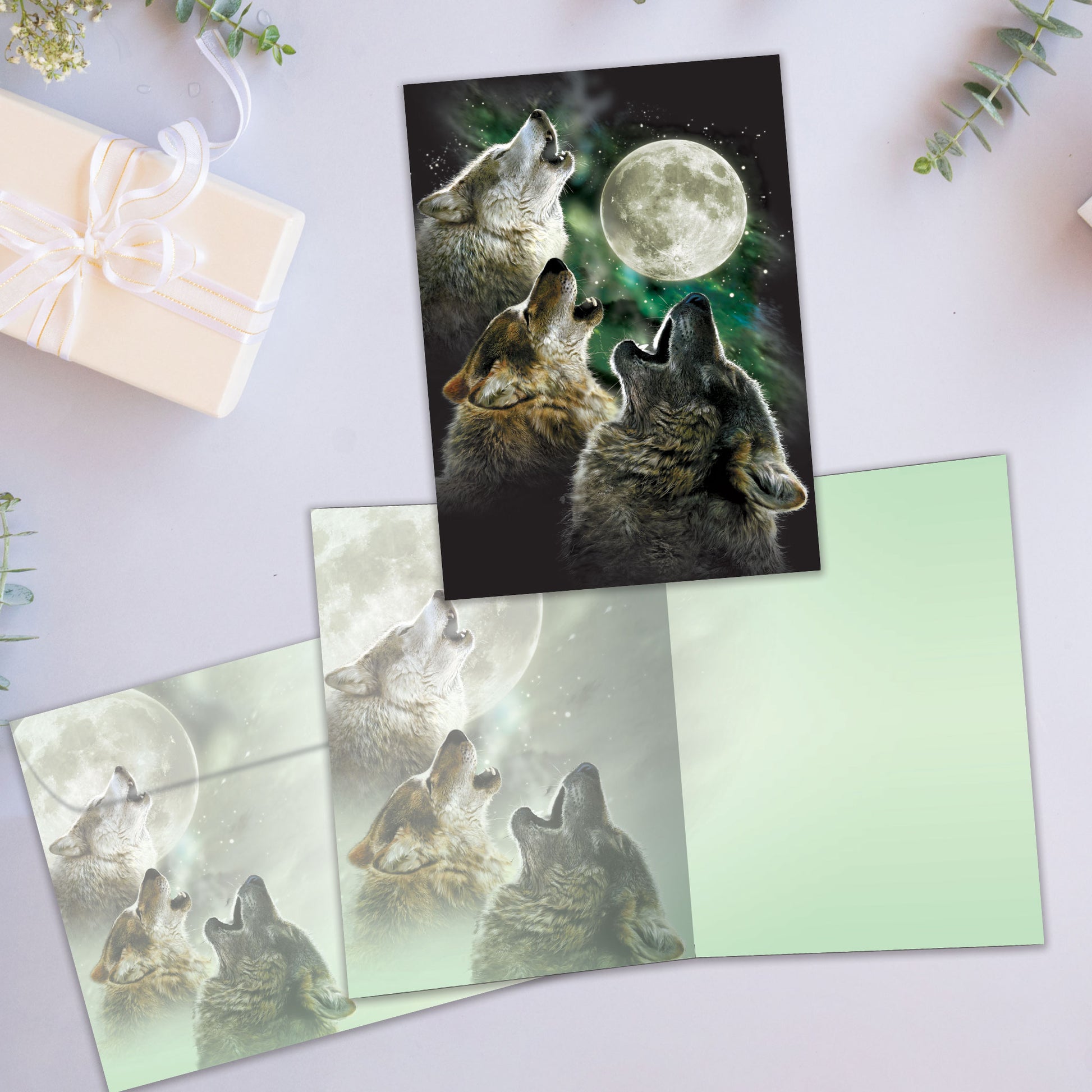 Front and inside view of an All Occasion greeting card showcasing three wolves howling at a full moon, joyful message, and matching envelope.