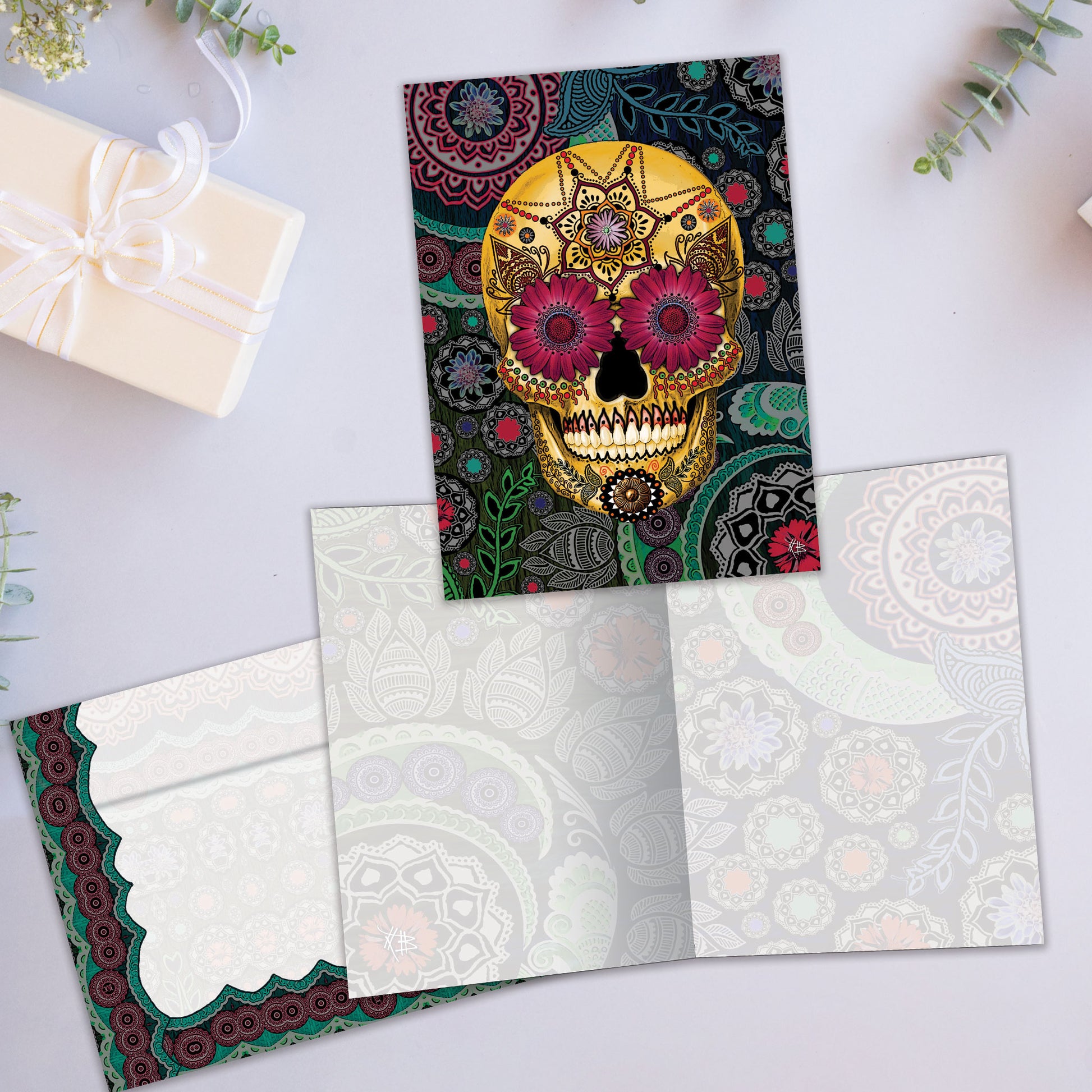 Front and inside view of an All Occasion greeting card showcasing a skull and paisley designs, along with a matching envelope.