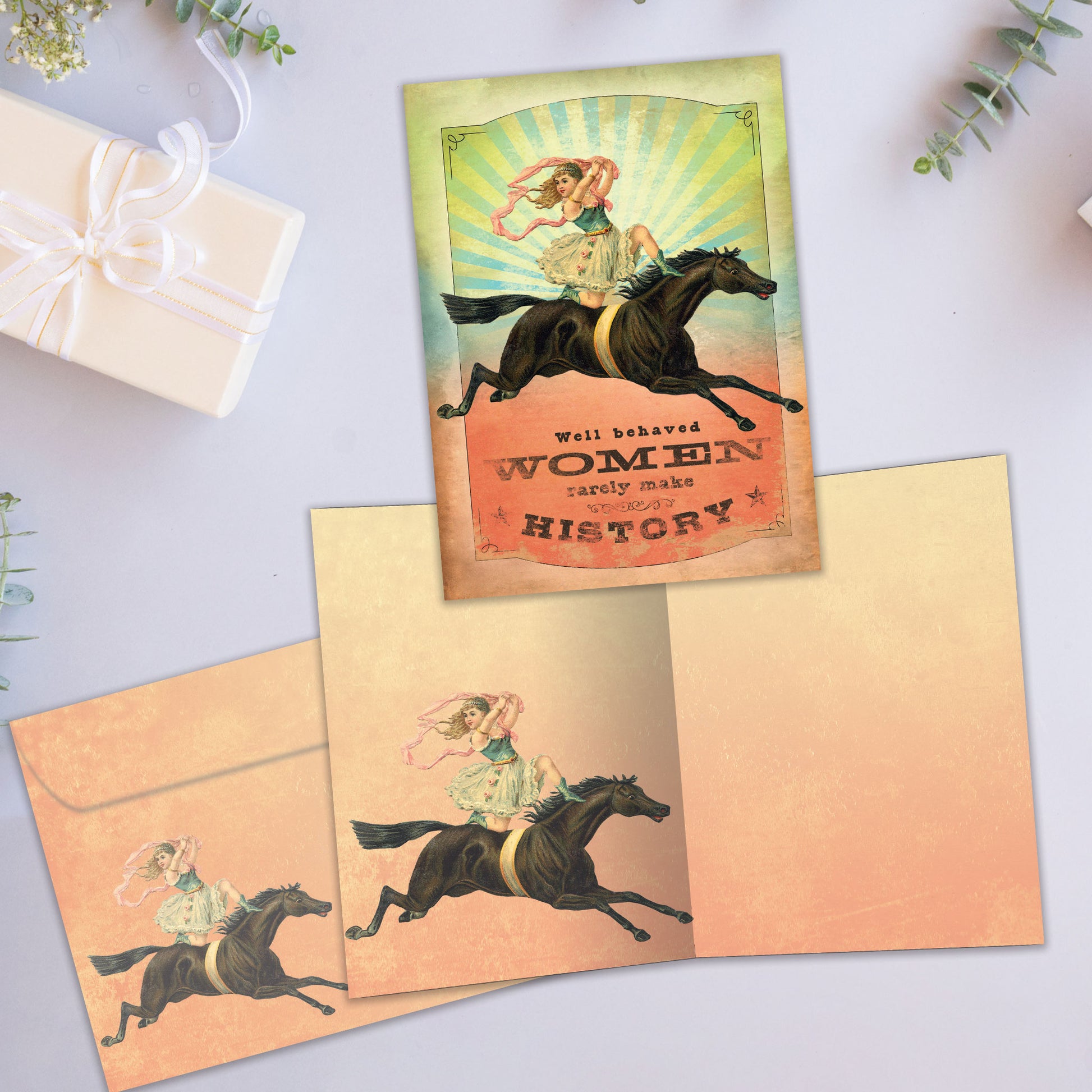Front and inside view of an All Occasion greeting card showcasing a vintage illustration of a woman on a horse, with a matching envelope and a quote about well-behaved women.