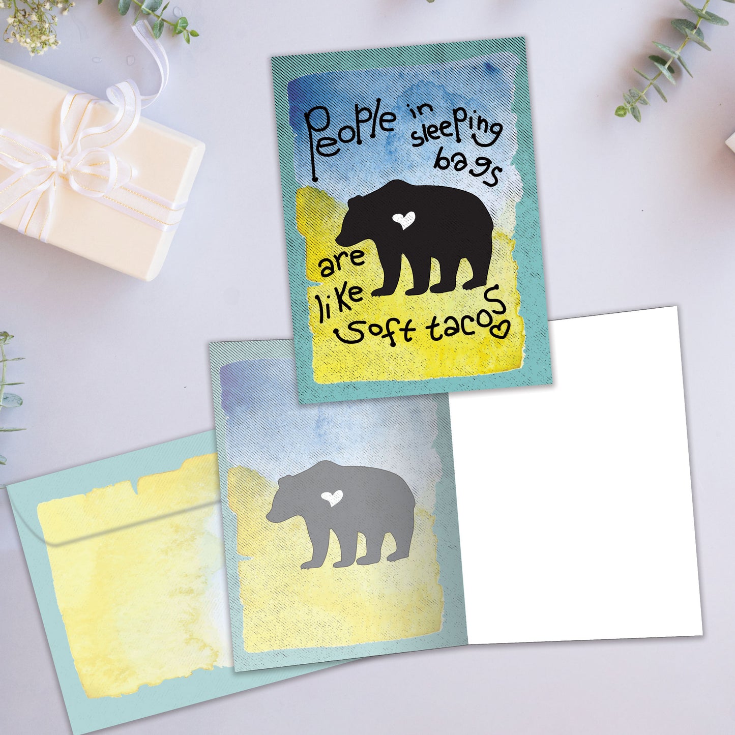 Front and inside view of an All Occasion greeting card showcasing a bear silhouette on the cover with a message, with a matching envelope.