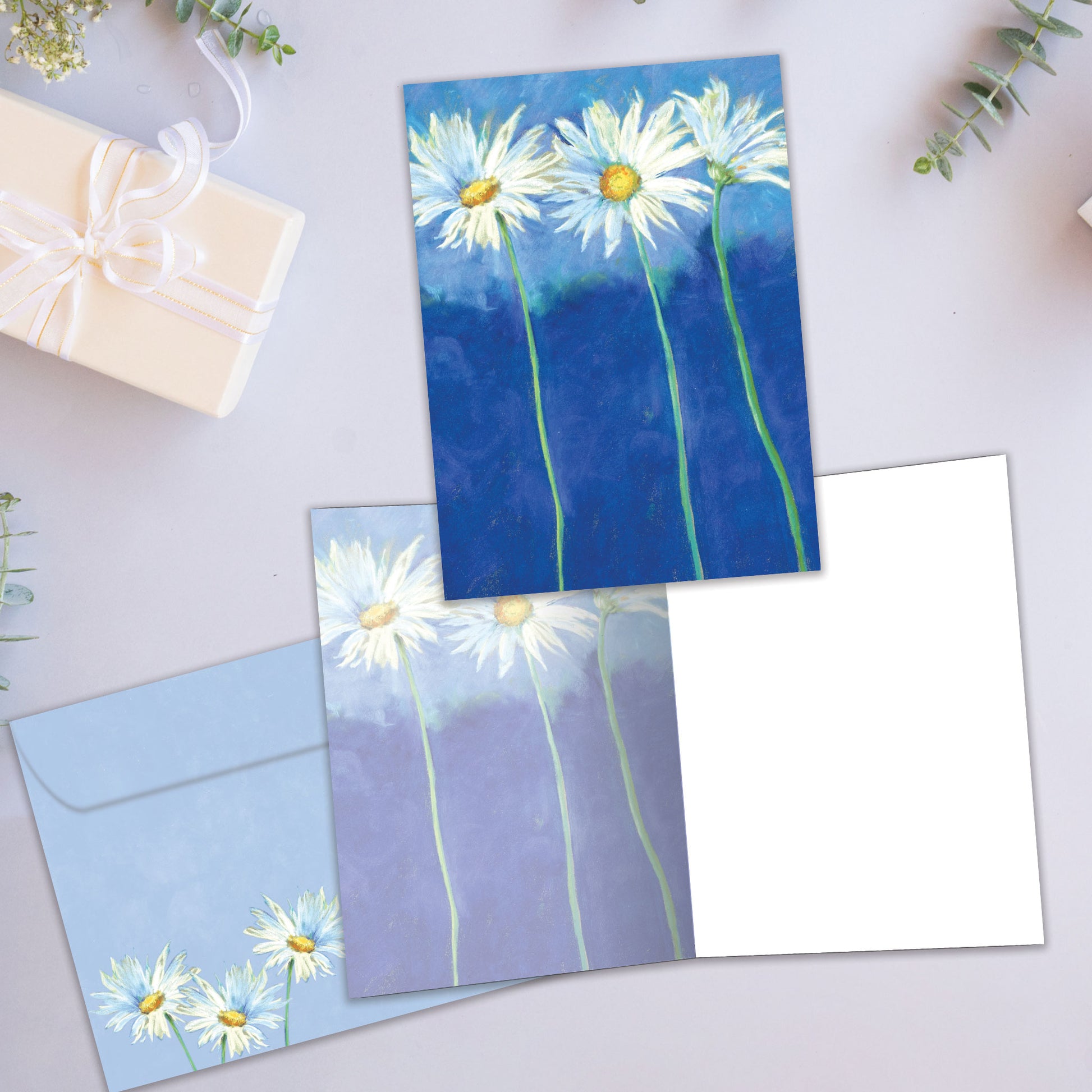 Front and inside view of an All Occasion greeting card showcasing daisies on a blue background, with a matching envelope.