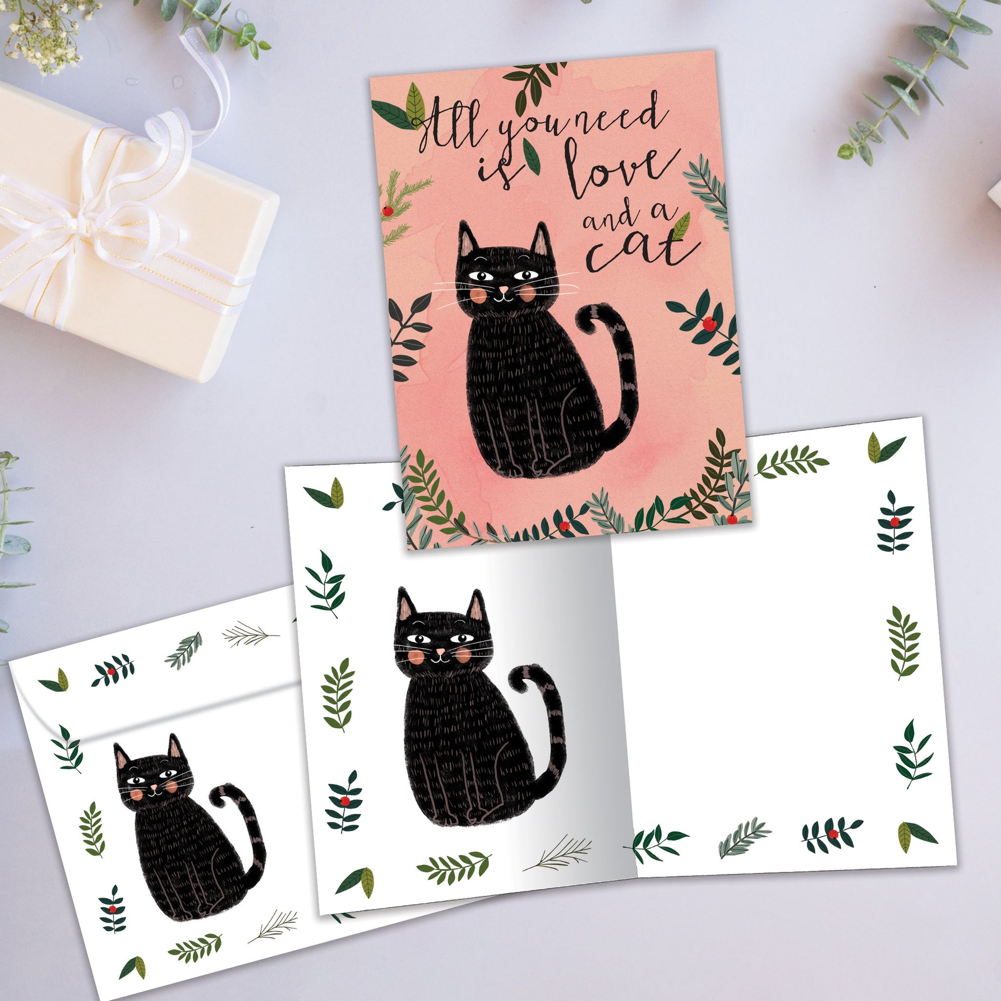 Front and inside view of an All Occasion greeting card showcasing a cat and the message 'all you need is love and a cat,' with a matching envelope.