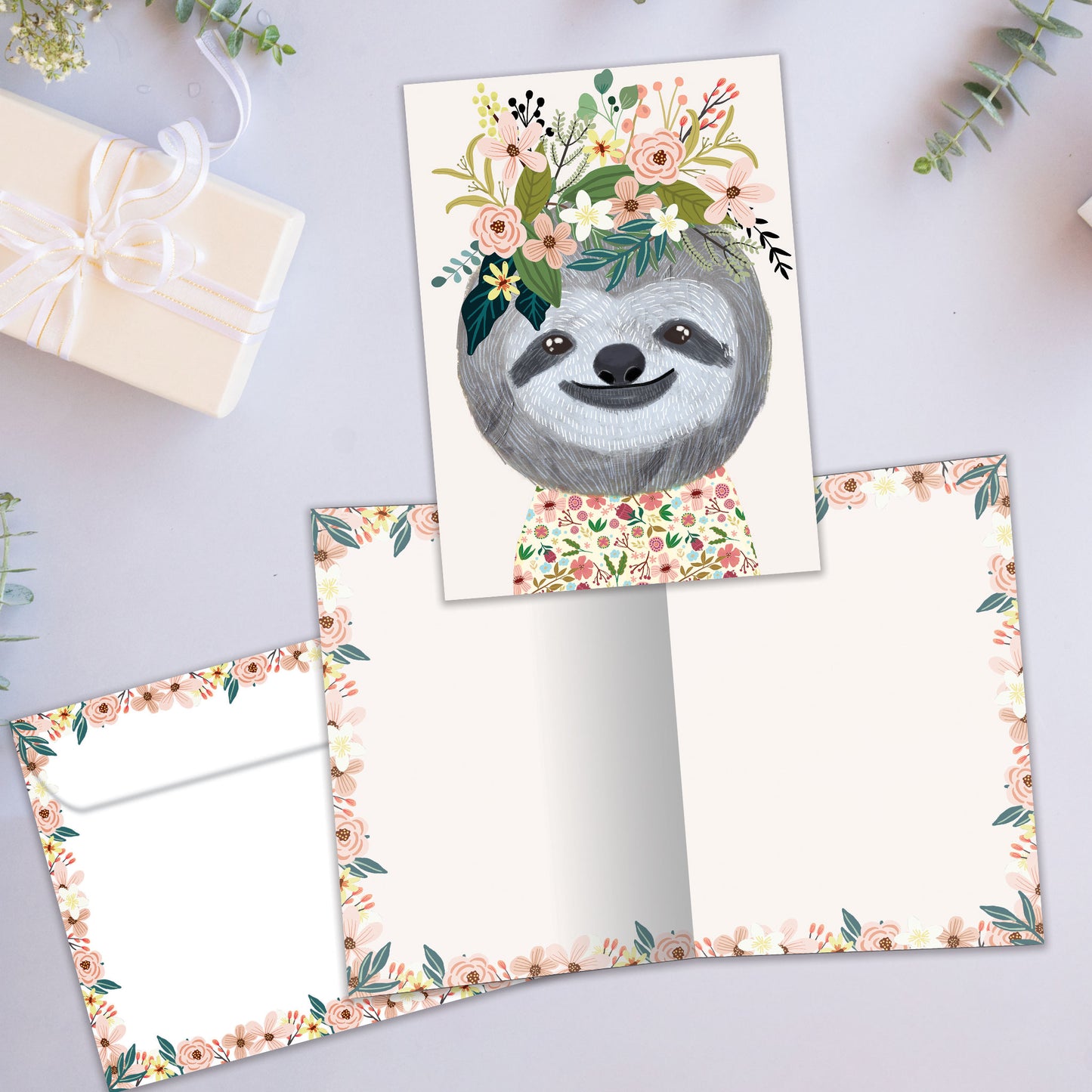 Front and inside view of an All Occasion greeting card showcasing a happy sloth and flowers, with a matching envelope.