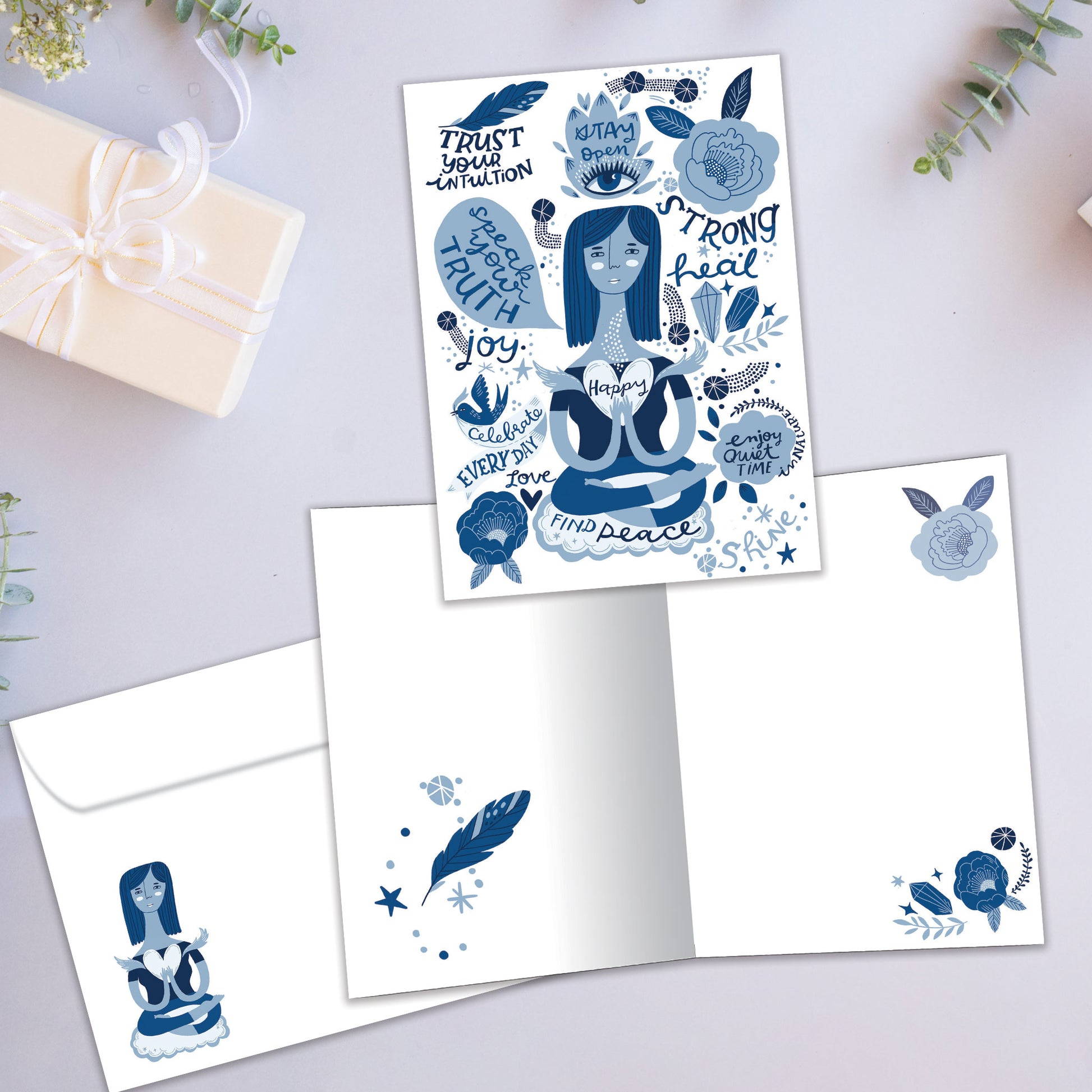 Front and inside view of an All Occasion greeting card showcasing a woman meditating, surrounded by peaceful messages, with blue imagery and matching envelope.