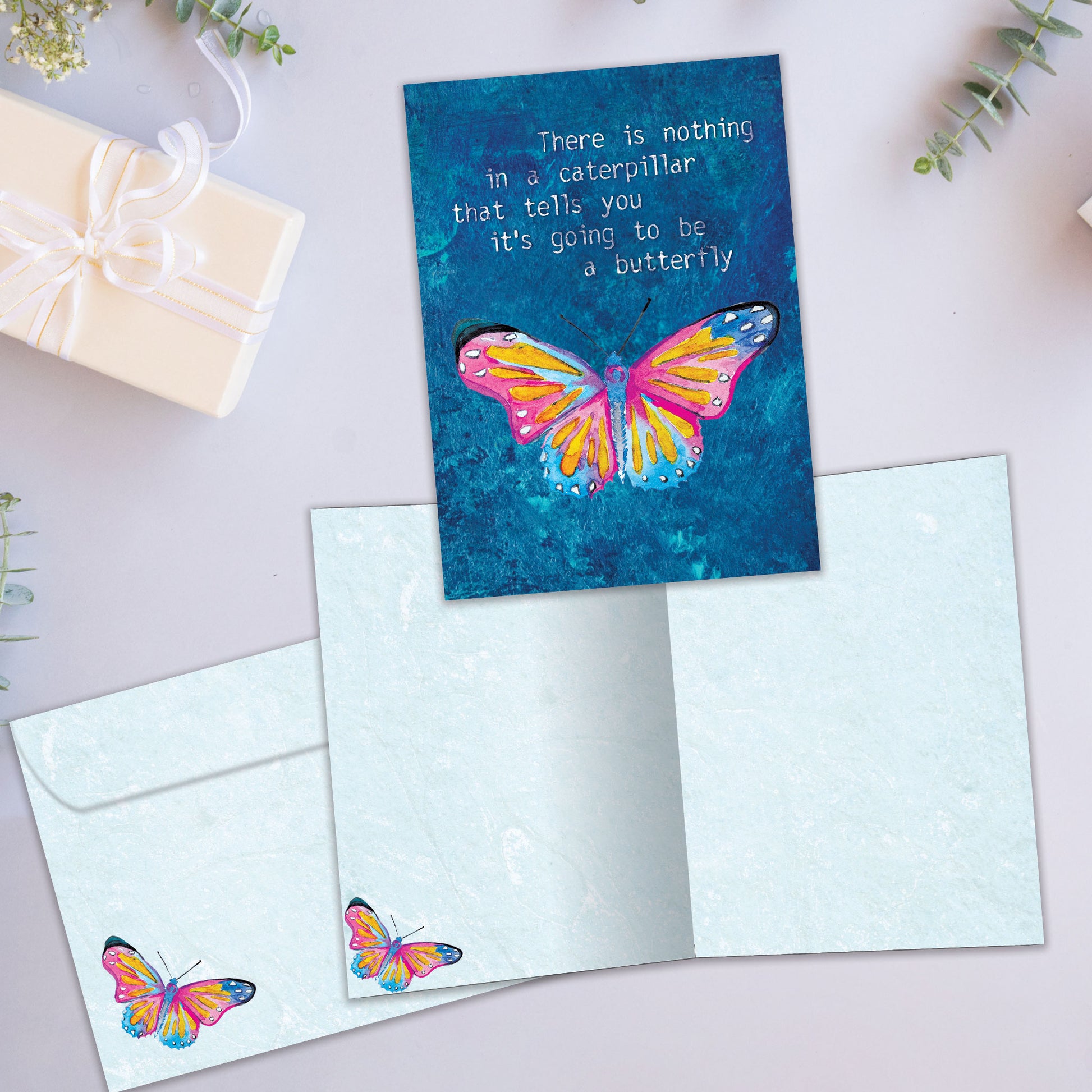Front and inside view of an All Occasion greeting card featuring a vibrant butterfly on a dark blue background with an uplifting message, plus a matching envelope.