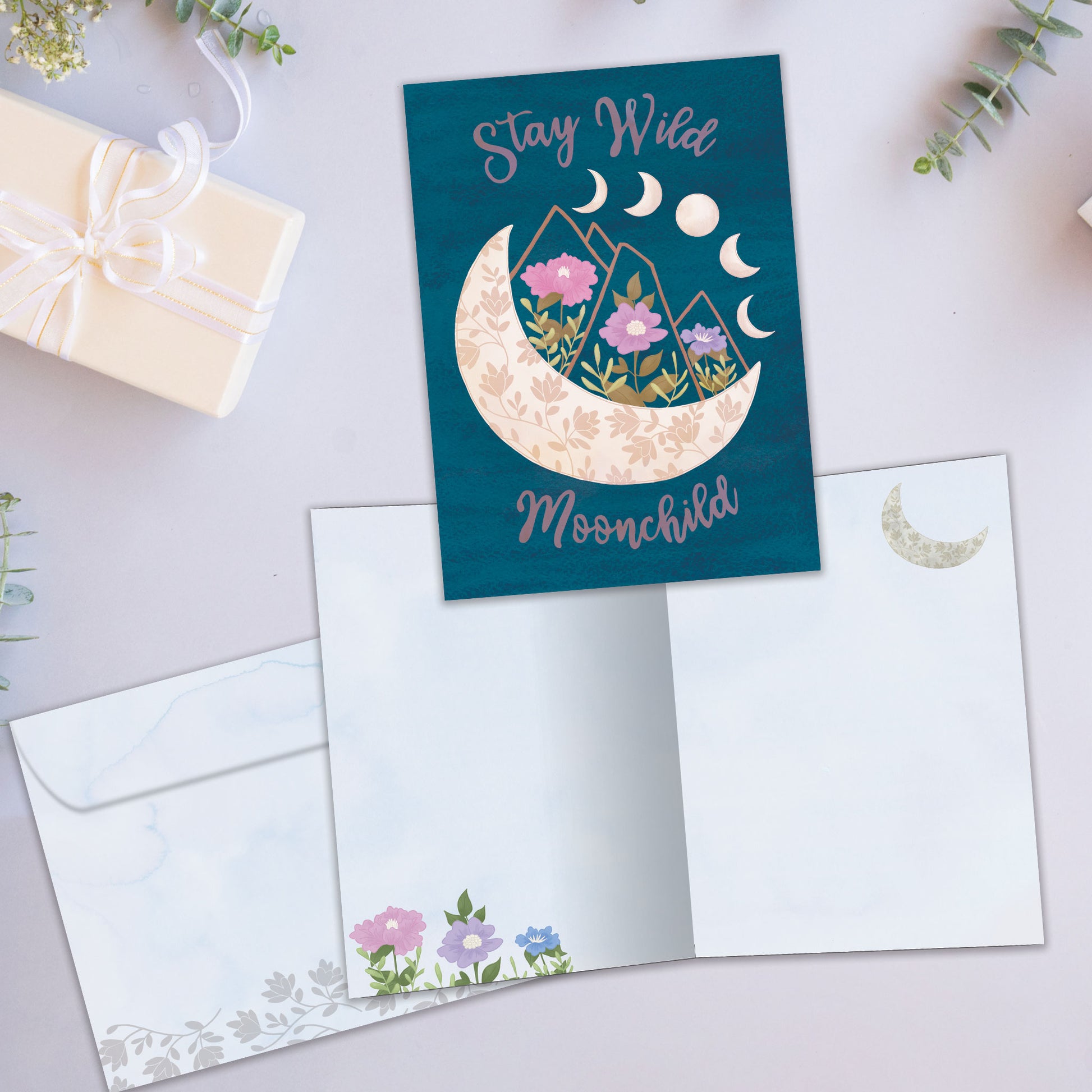 Front and inside view of an All Occasion greeting card featuring a moon and flowers on a dark blue background, plus a matching envelope.