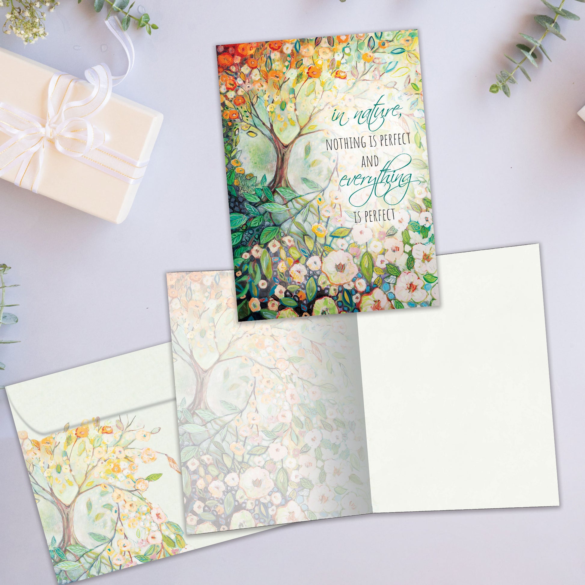 Front and inside view of an All Occasion greeting card featuring a tree and flowers illustration, plus a matching envelope.