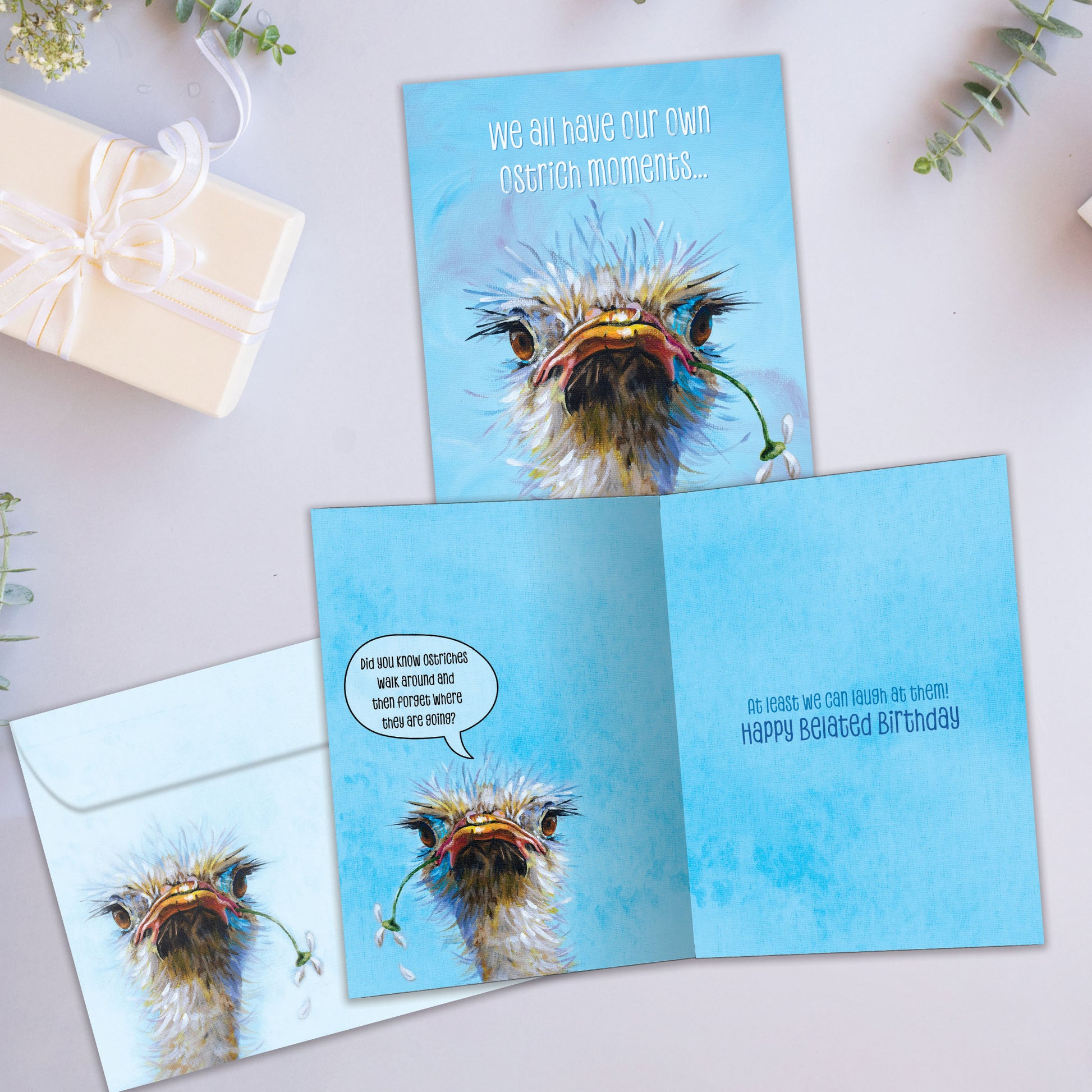 Front and inside view of a Birthday greeting card showcasing an illustrated ostrich face with the message "we all have our own ostrich moments...", with a matching envelope.