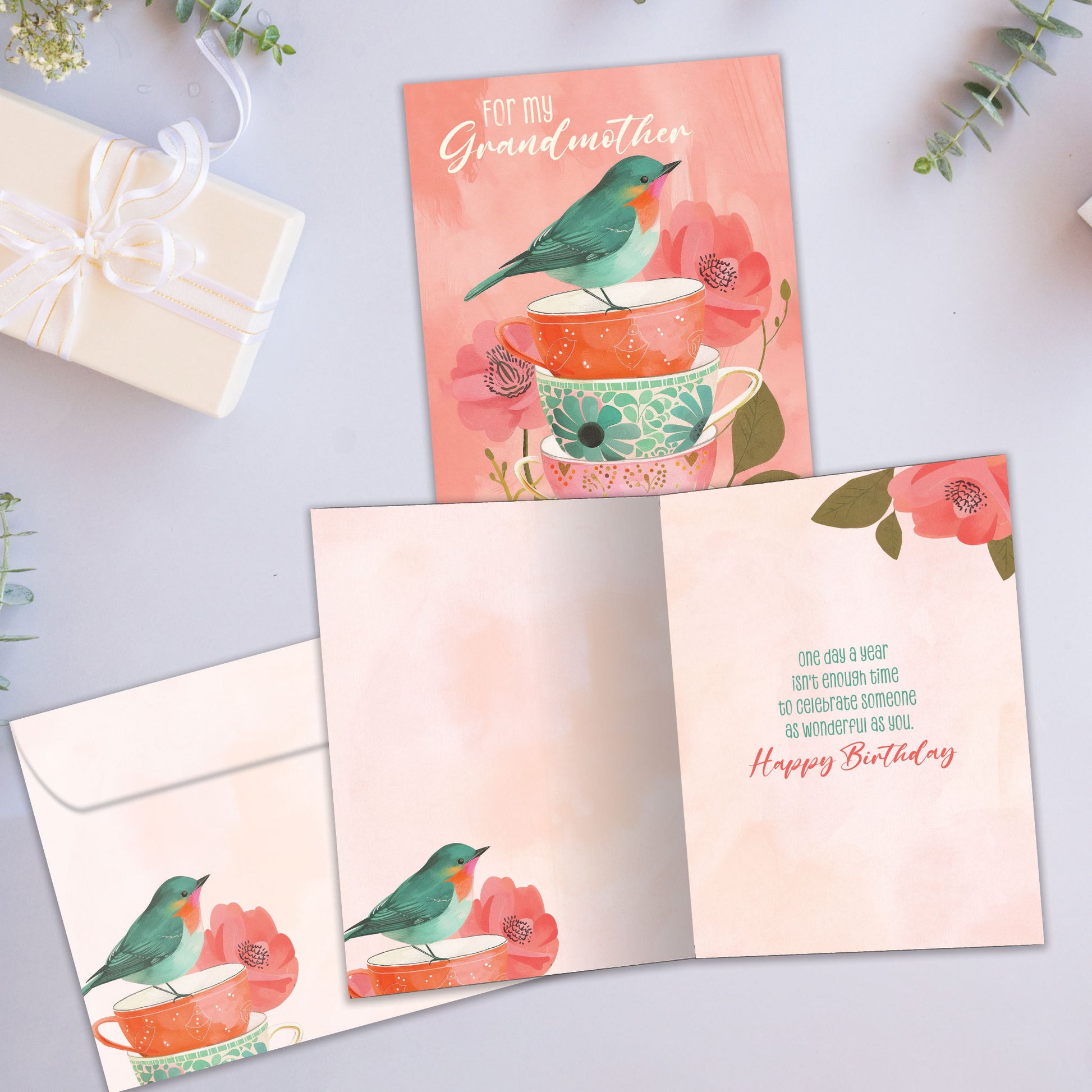 Front and inside view of a Birthday greeting card showcasing an illustration of a bird standing on a stack of teacups in beautiful pastel colors, with a matching envelope.
