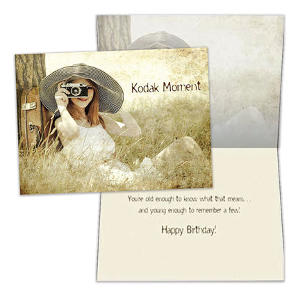 Front and inside view of a Birthday greeting card featuring a woman sitting next to a tree taking a picture with the words "Kodak moment", with matching design details inside.