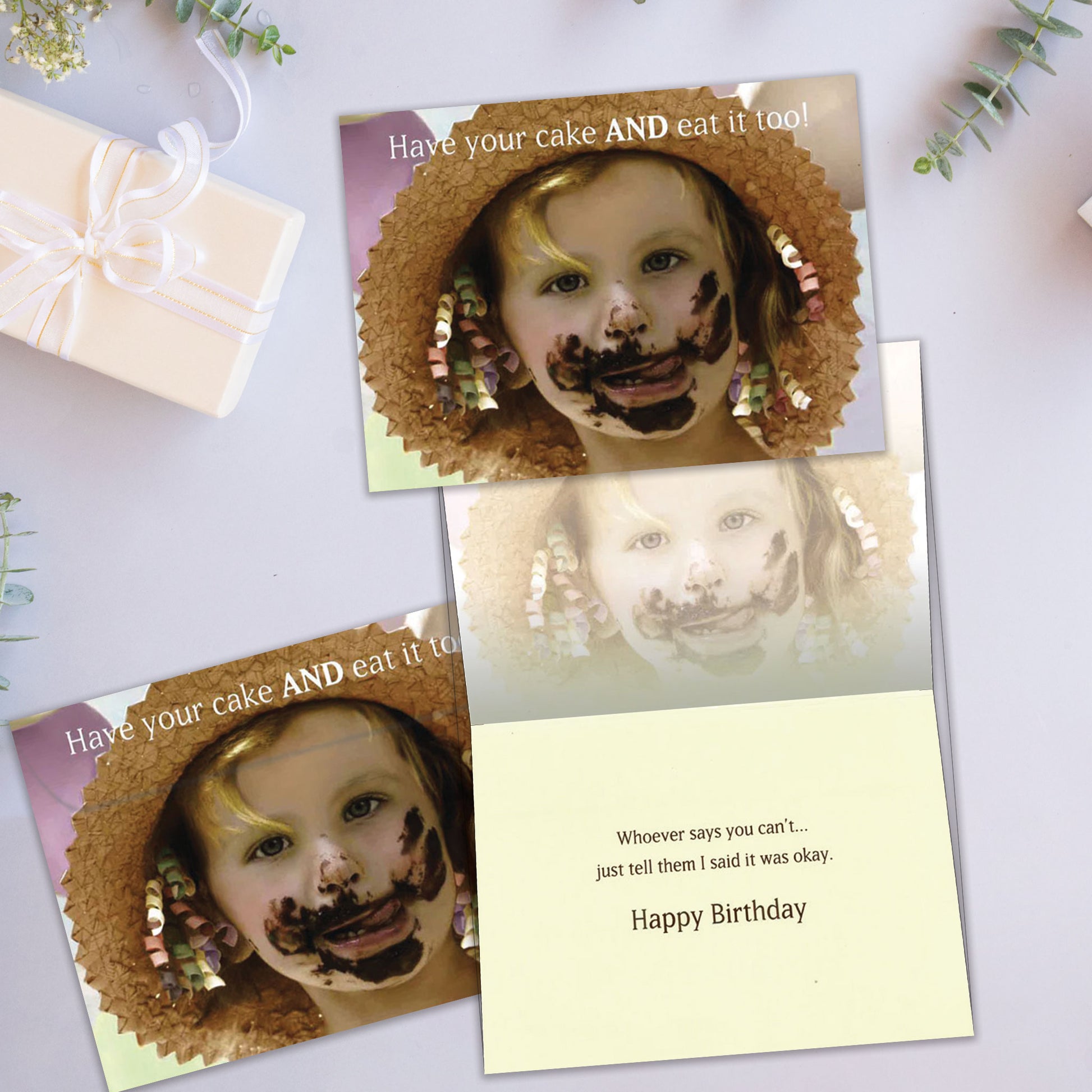 Front and inside view of a Birthday greeting card showcasing a close-up of a girl with cake on her face and a message about eating cake, with a matching envelope.