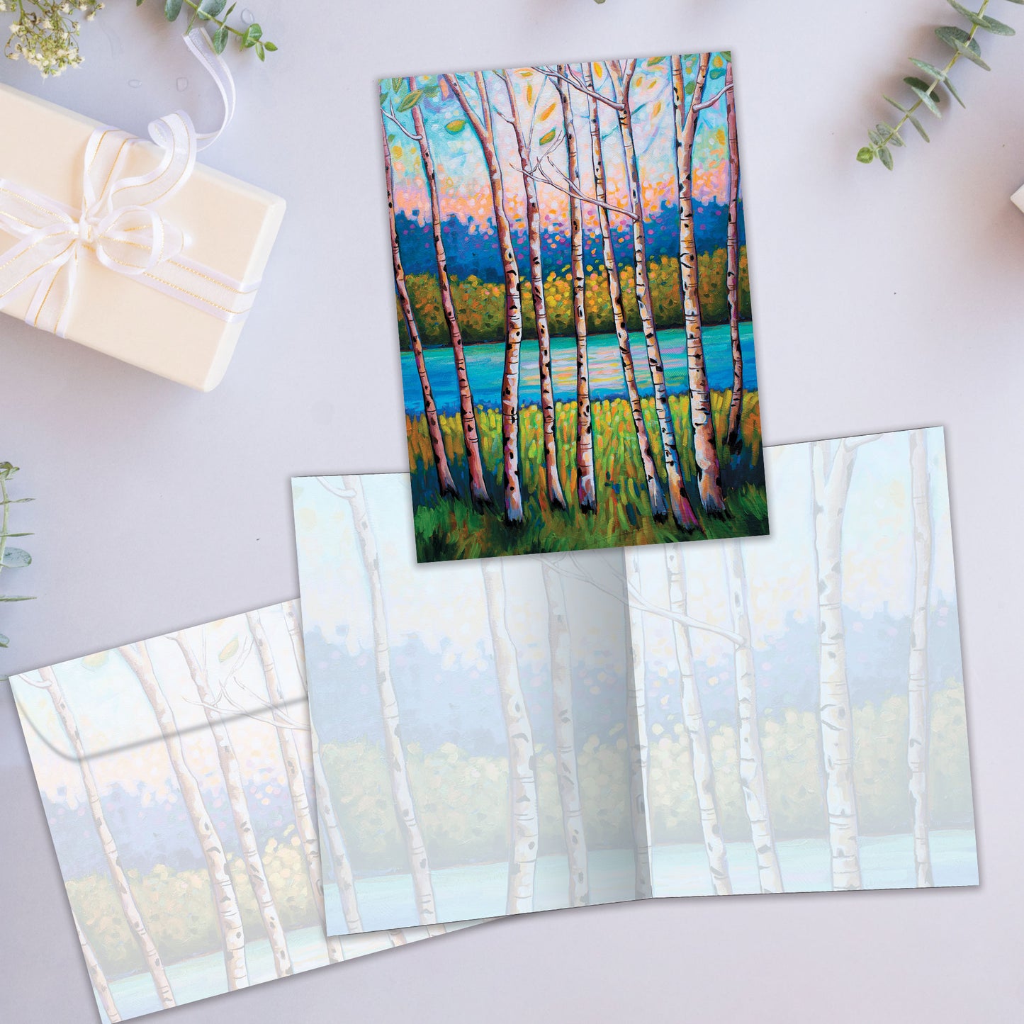 Front and inside view of an All Occasion greeting card featuring a tranquil forest and stream illustration, plus a matching envelope.