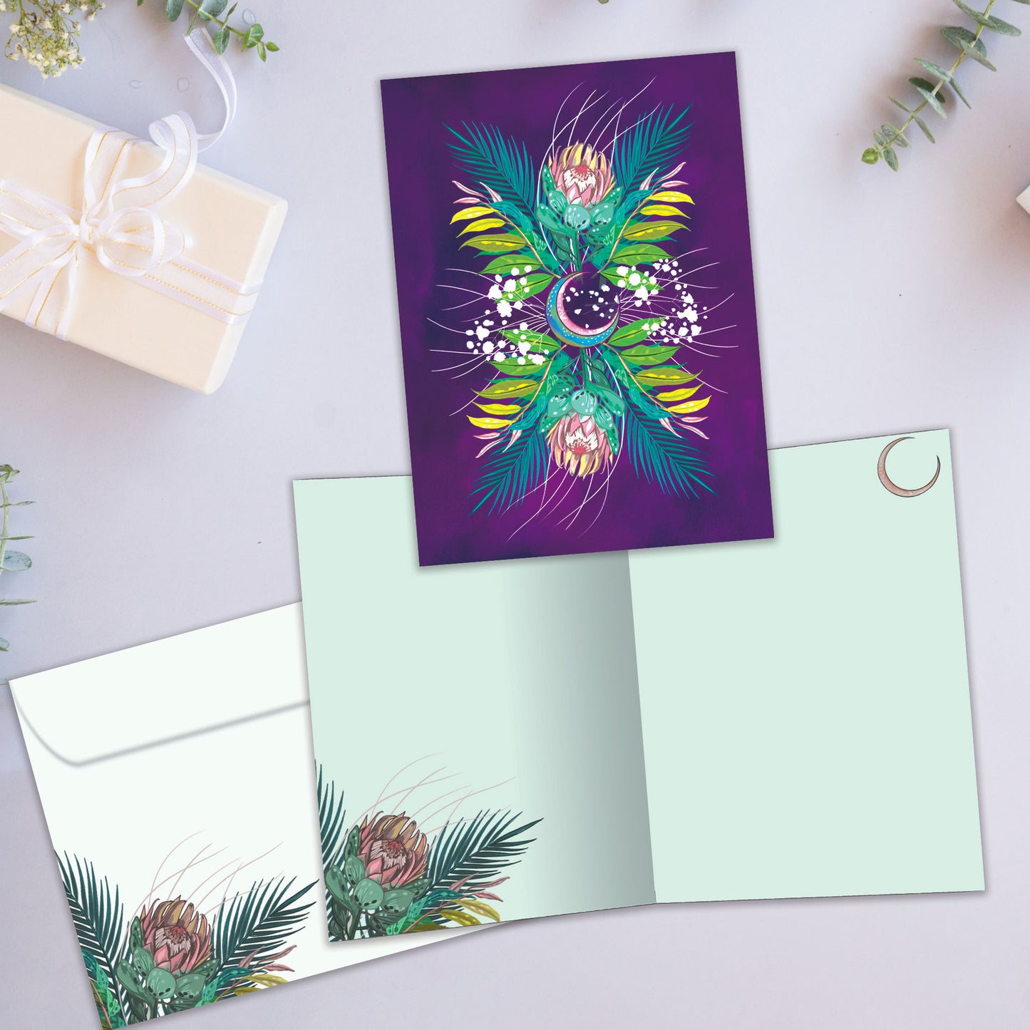 Front and inside view of an All Occasion greeting card featuring a lively, colourful illustration of foliage and the moon, plus a matching envelope.