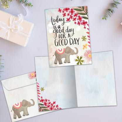 Front and inside view of an All Occasion greeting card featuring a lively elephant and flower illustration with a good day message, plus matching envelope.
