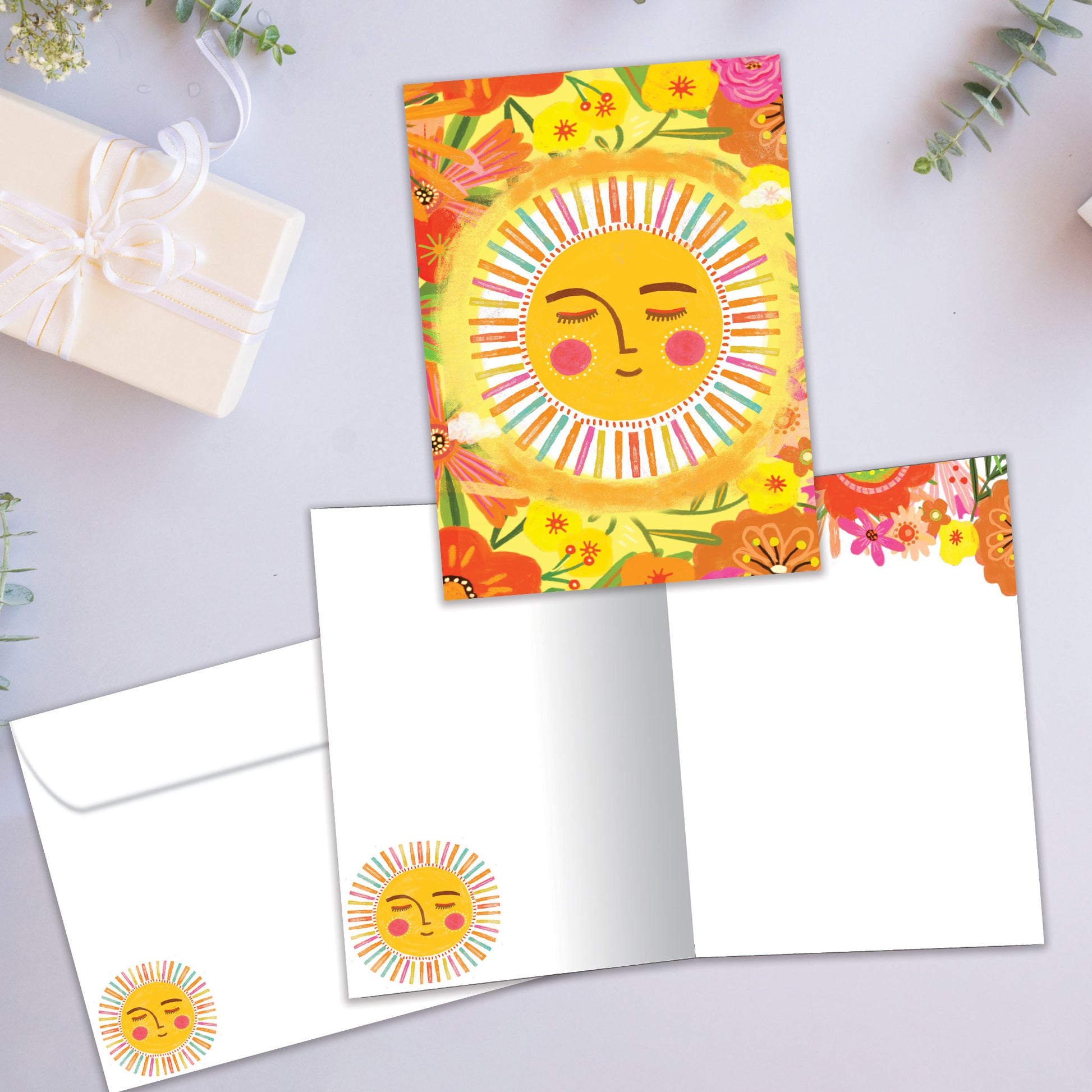 Front and inside view of an All Occasion greeting card featuring a cheerful sun with vibrant flowers, plus a matching envelope.