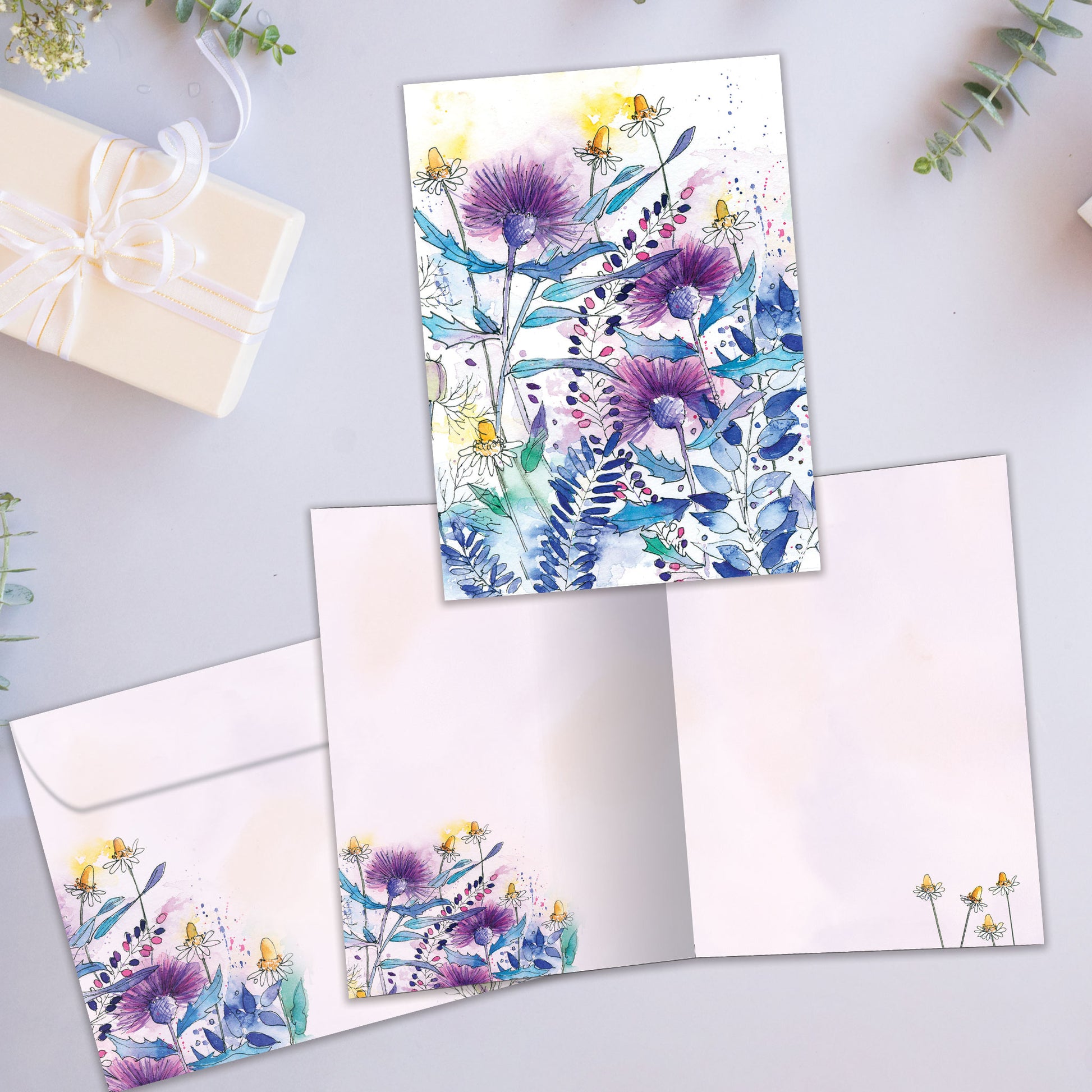 Front and inside view of an All Occasion greeting card with purple and blue flowers on a white background, plus matching envelope design.