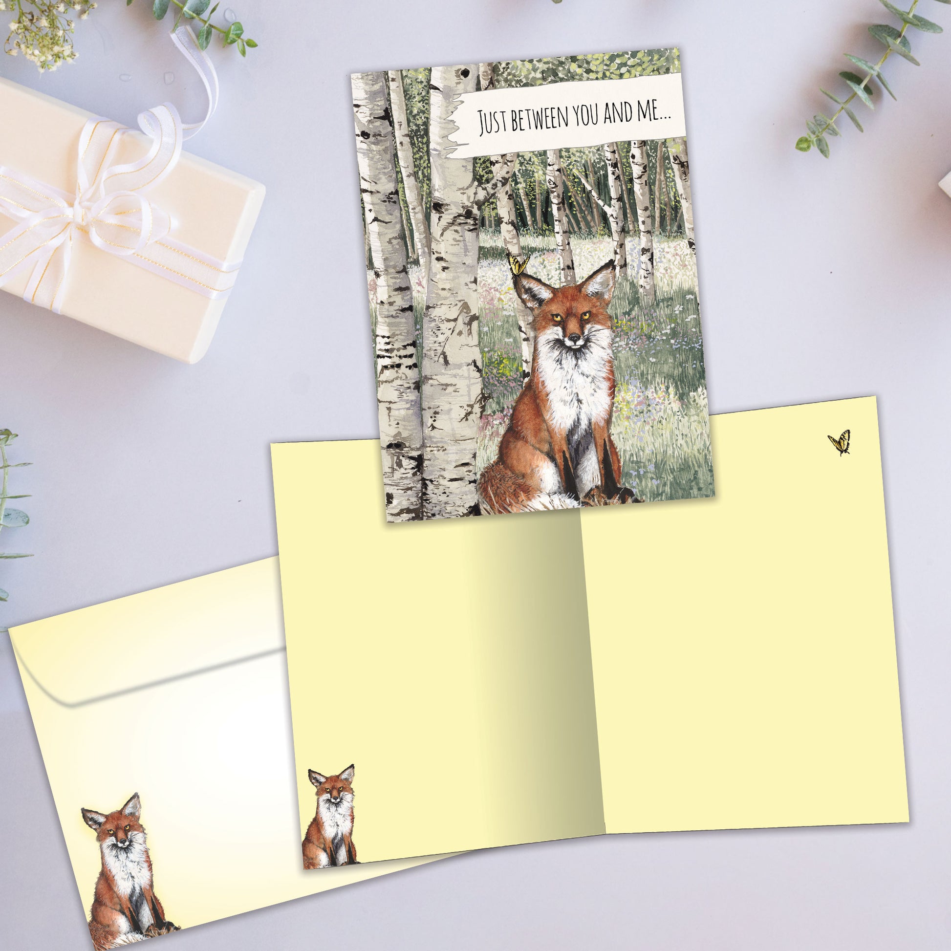 Front and inside view of an All Occasion greeting card displaying a fox and the message 'just between you and me...' with matching envelope design.