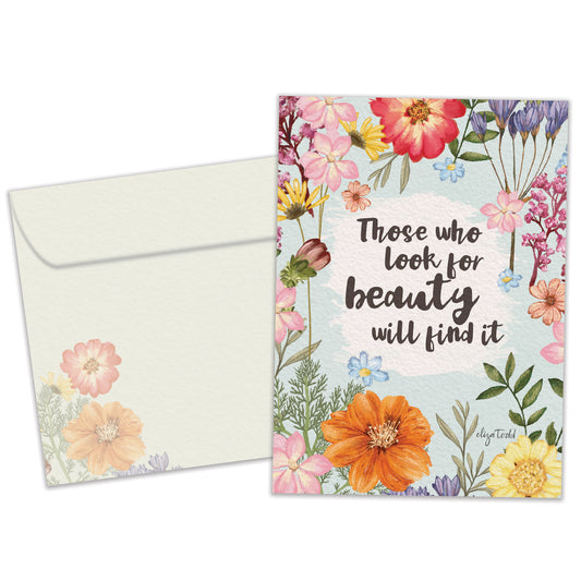 Front view of an Anniversary greeting card and matching envelope featuring a message about finding beauty surrounded by floral artwork.
