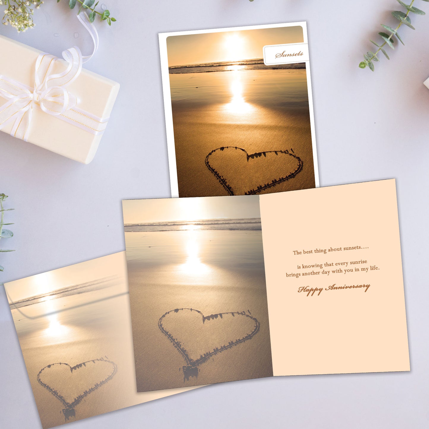 Front and inside view of an Anniversary greeting card showcasing a sunset photo with a heart drawn in the sand, with a matching envelope. 
