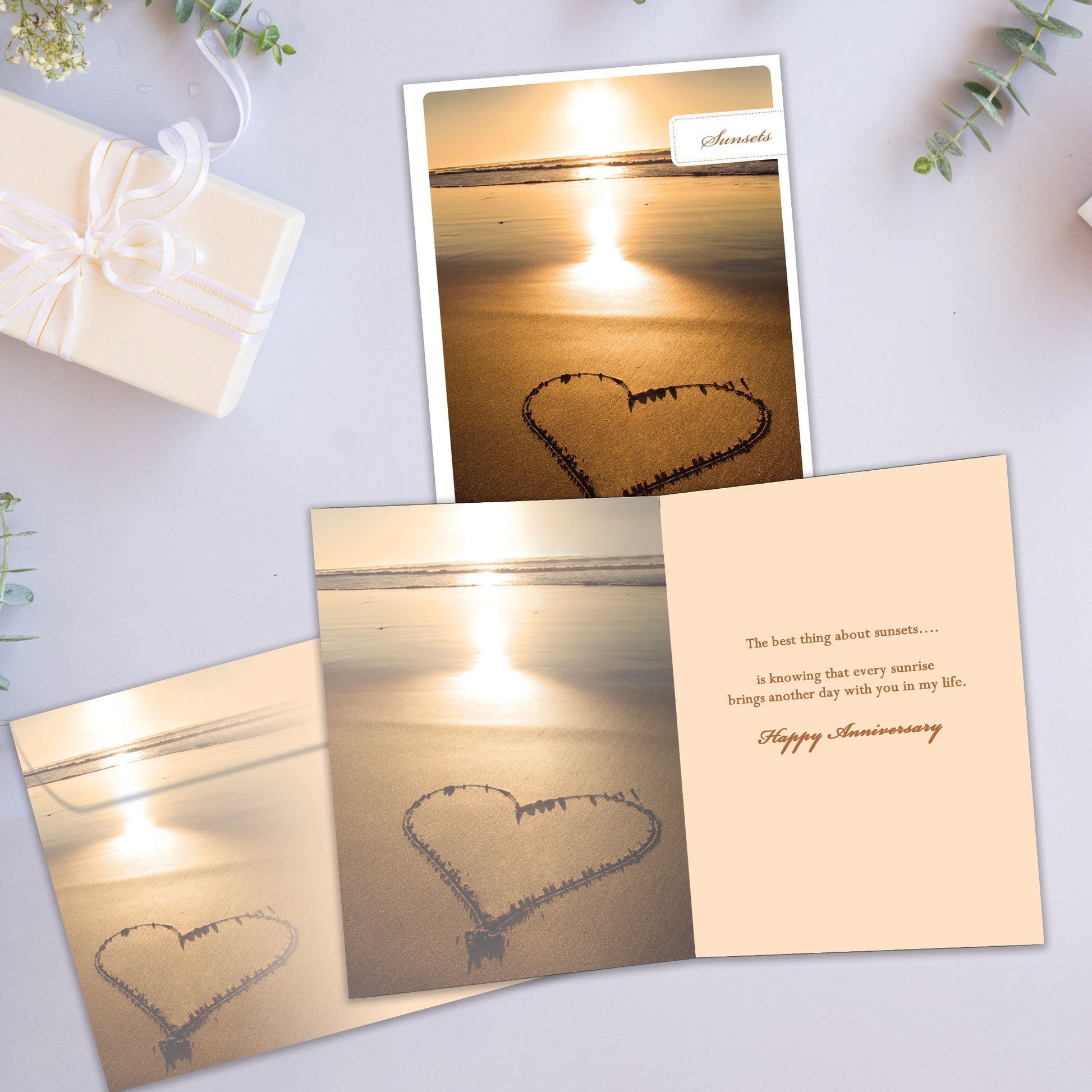Front and inside view of an Anniversary greeting card showcasing a sunset photo with a heart drawn in the sand, with a matching envelope. 