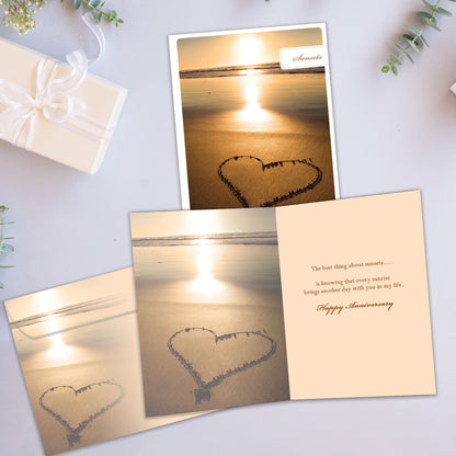 Front and inside view of an Anniversary greeting card showcasing a sunset photo with a heart drawn in the sand, with a matching envelope. 