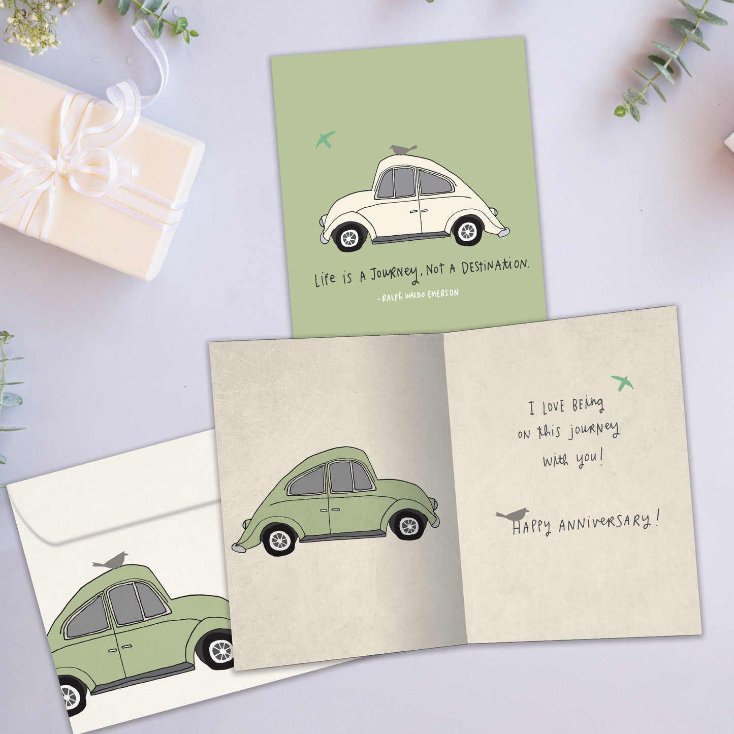 Front and inside view of an Anniversary greeting card showcasing a car illustration with an uplifting life message, with a matching envelope. 