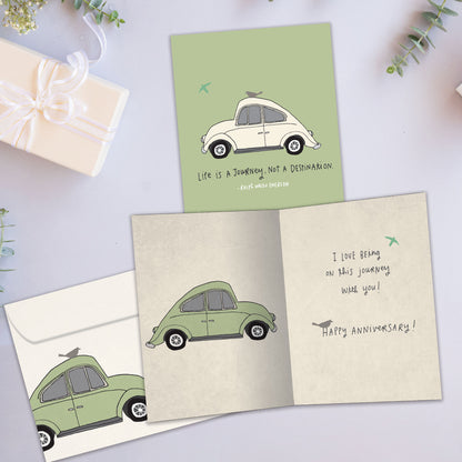 Front and inside view of an Anniversary greeting card showcasing a car illustration with an uplifting life message, with a matching envelope. 