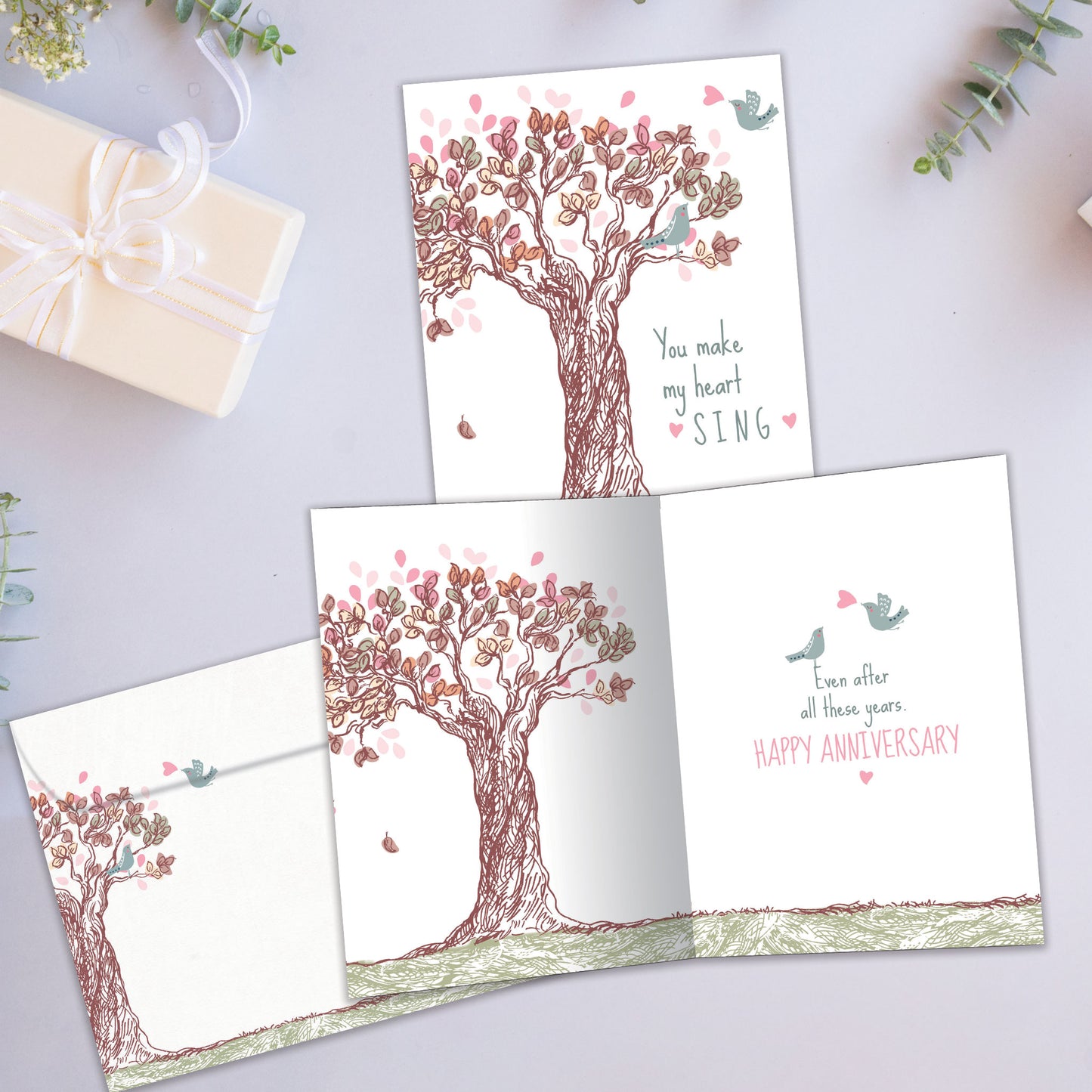 Front and inside view of an Anniversary greeting card showcasing a tree illustration with the message "you make my heart sing," with a matching envelope.