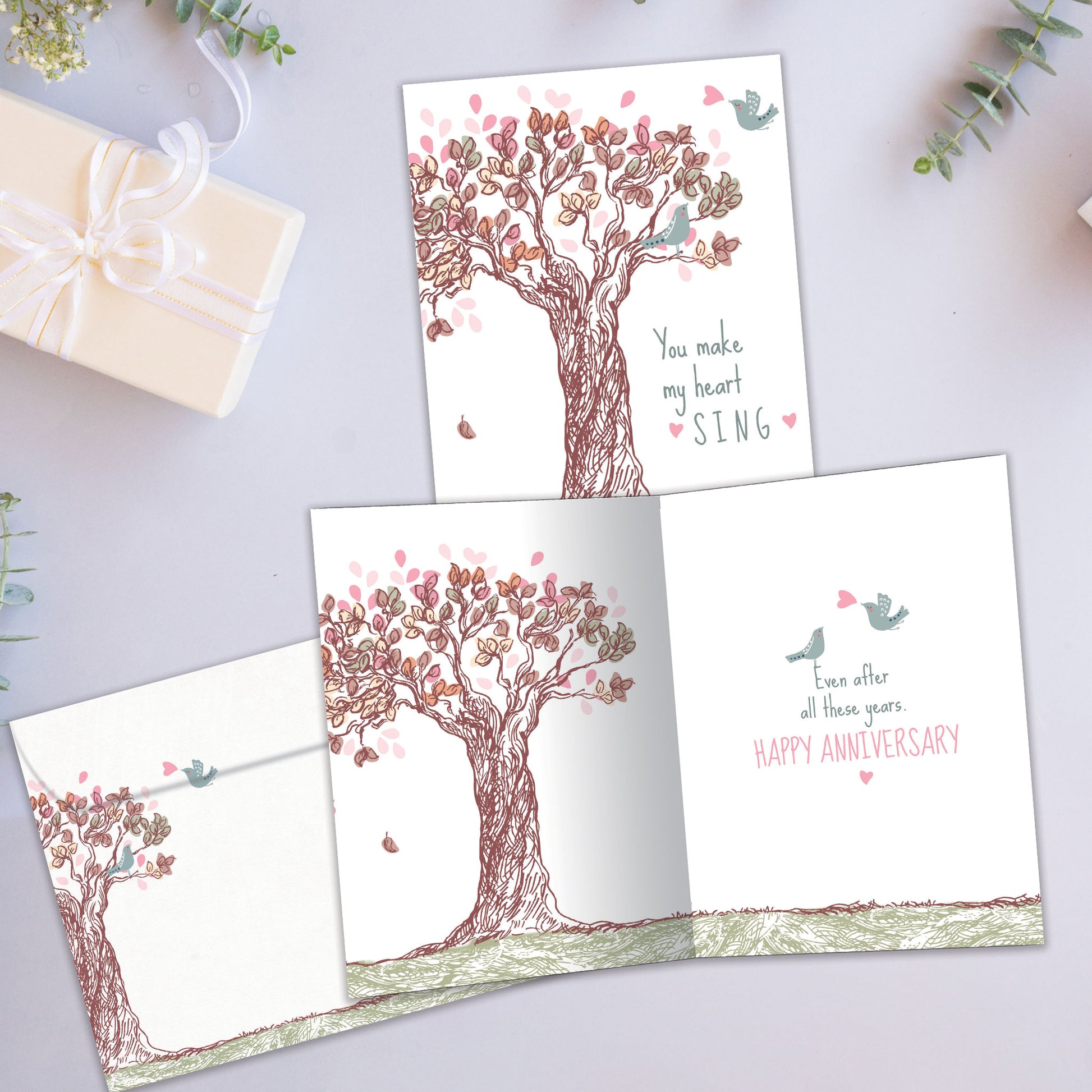 Front and inside view of an Anniversary greeting card showcasing a tree illustration with the message "you make my heart sing," with a matching envelope.