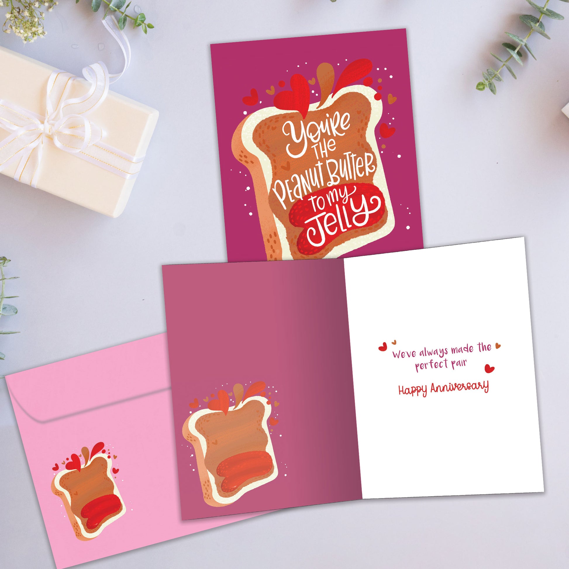 Front and inside view of an Anniversary greeting card showcasing the playful message "You're the peanut butter to my jelly" and a matching illustration, with a matching envelope.