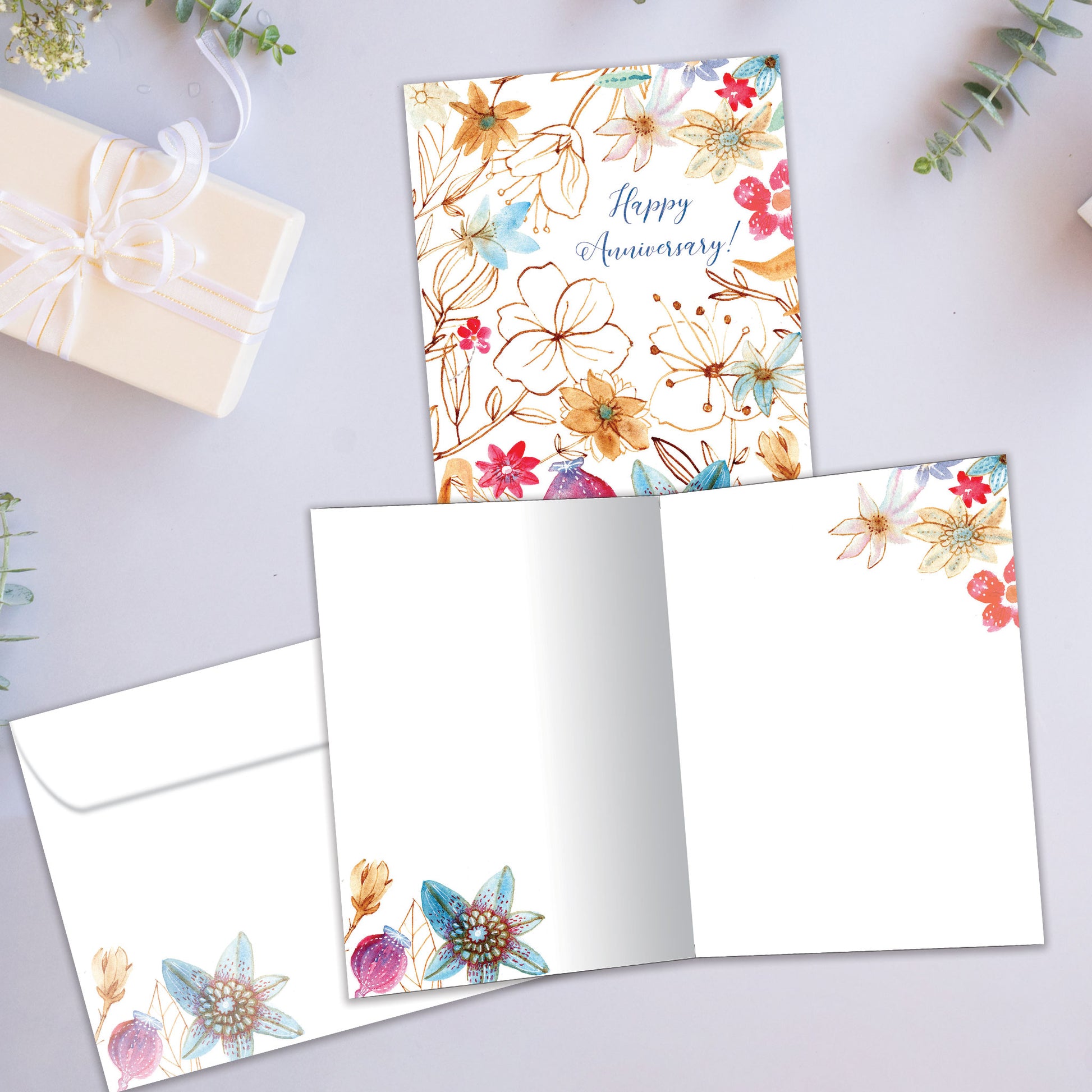 Front and inside view of an Anniversary greeting card showcasing "Happy Anniversary!" with floral accents, with a matching envelope.