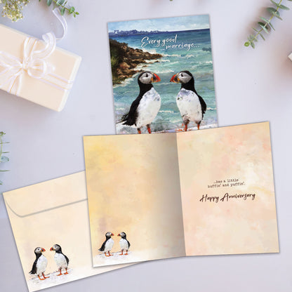 Front and inside view of an Anniversary greeting card showcasing two puffins by the ocean with a message, with a matching envelope.