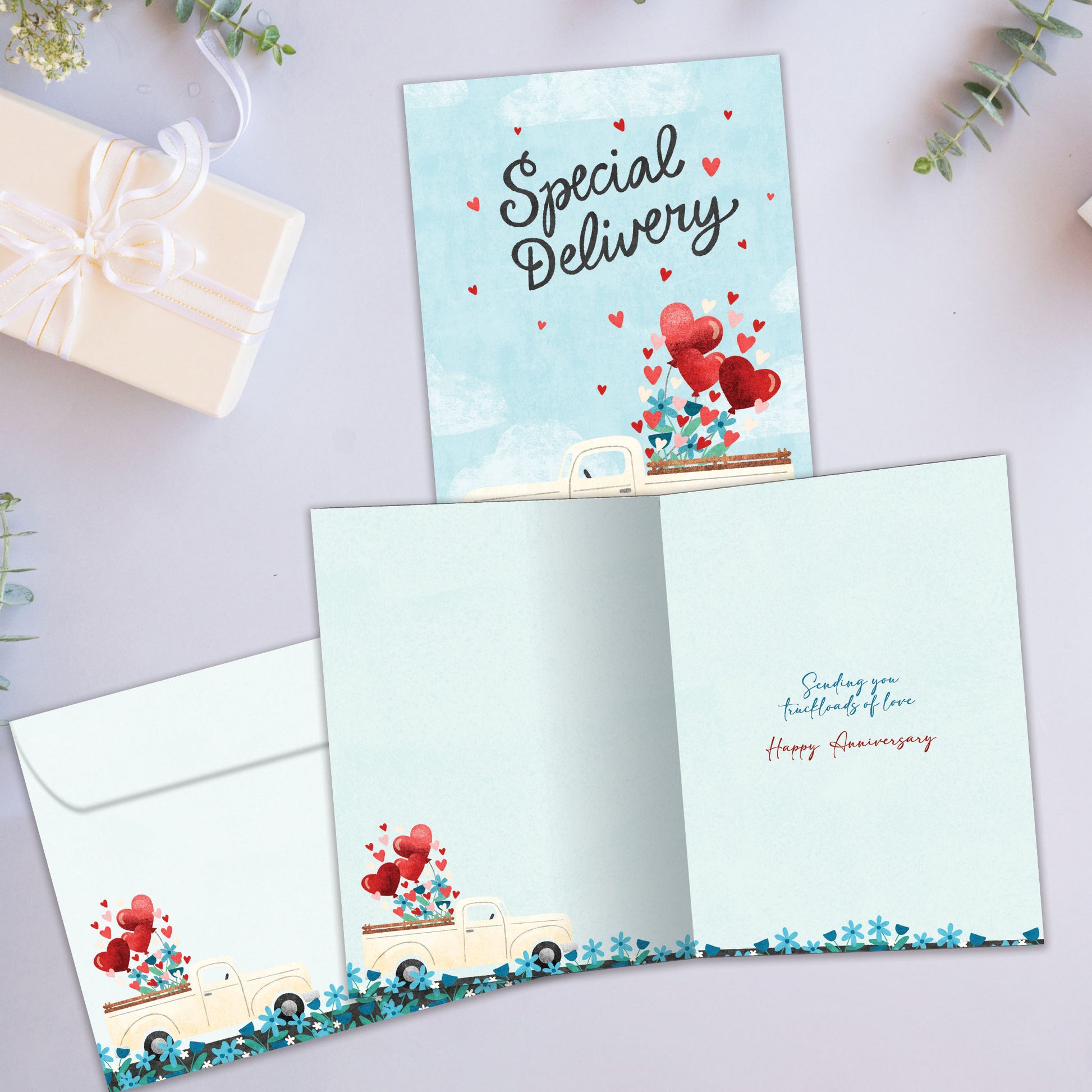 Front and inside view of an Anniversary greeting card showcasing a truck filled with hearts and the message "Special Delivery," with a matching envelope.