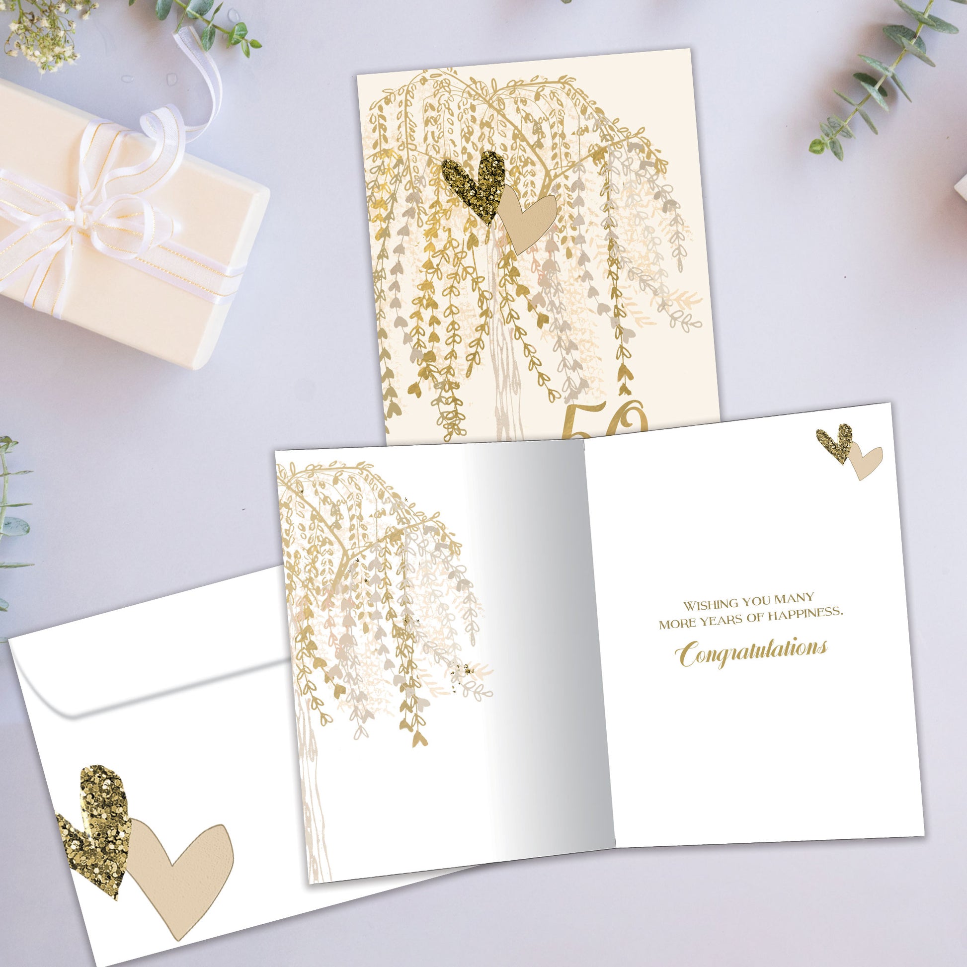 Front and inside view of an Anniversary greeting card showcasing "50 golden years" in gold writing with a tree of heart-shaped golden leaves, with a matching envelope.