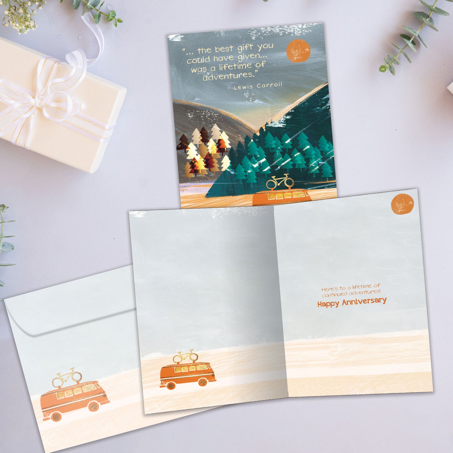 Front and inside view of an Anniversary greeting card showcasing a camper vehicle travelling through the mountains, with a matching envelope.