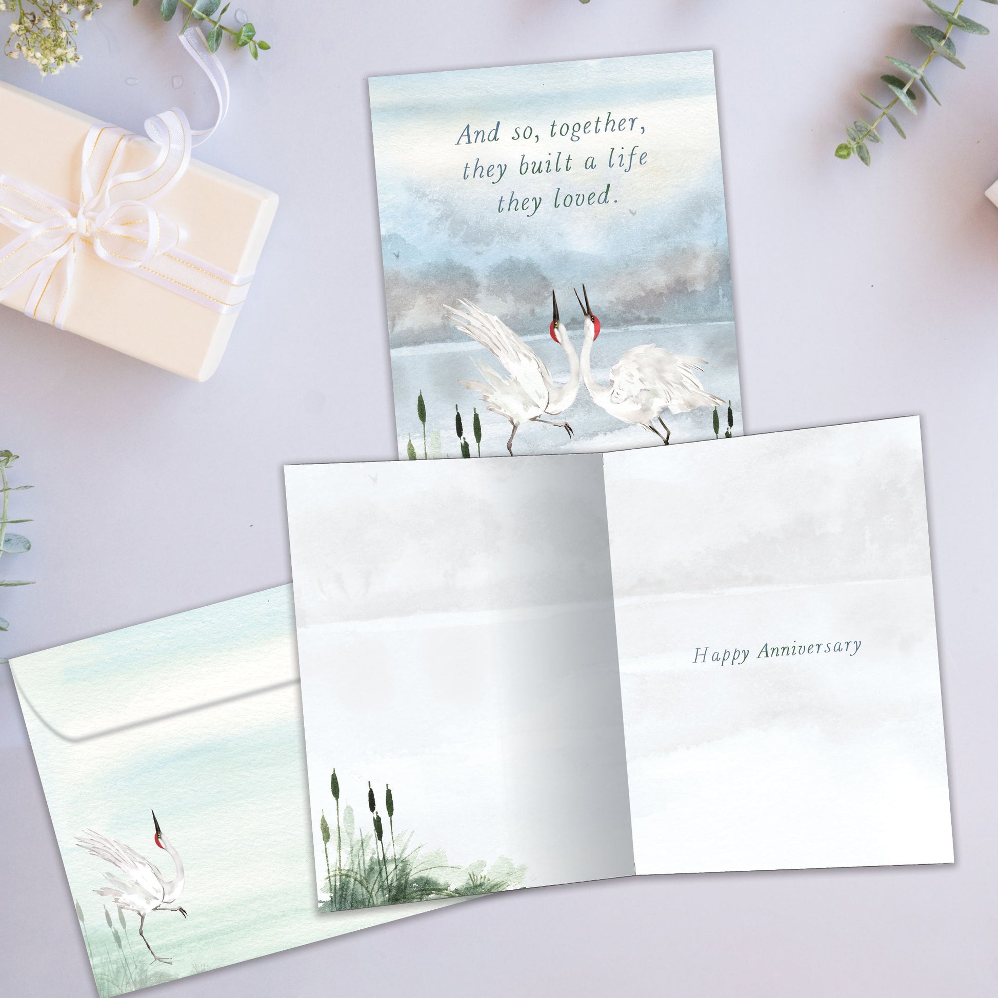 Front and inside view of an Anniversary greeting card showcasing two dancing cranes in a graceful pose, with a matching envelope.