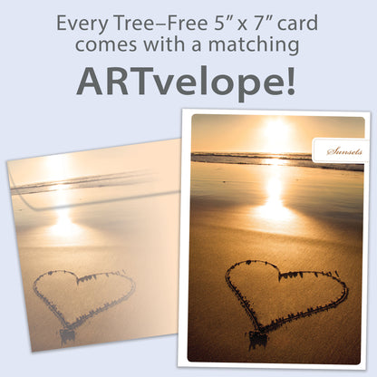 Front view of an Anniversary greeting card featuring a sunset photo with a heart drawn in the sand, with matching envelope artwork.