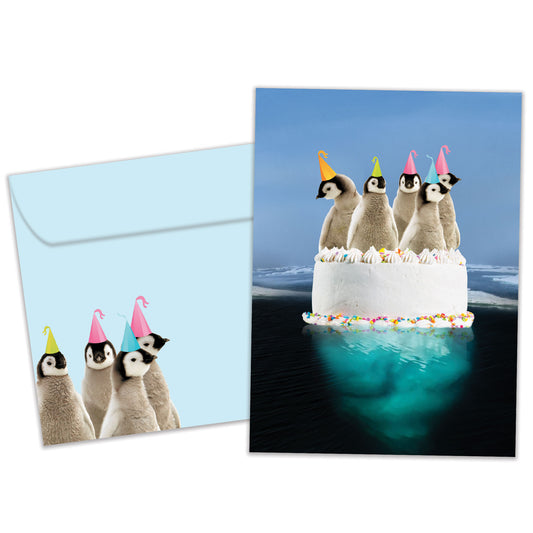 Front view of a Birthday greeting card and matching envelope featuring penguins floating atop a cake.