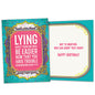 Front view of a Birthday greeting card featuring a funny message about lying about your age on a pink and teal background, with a matching envelope.