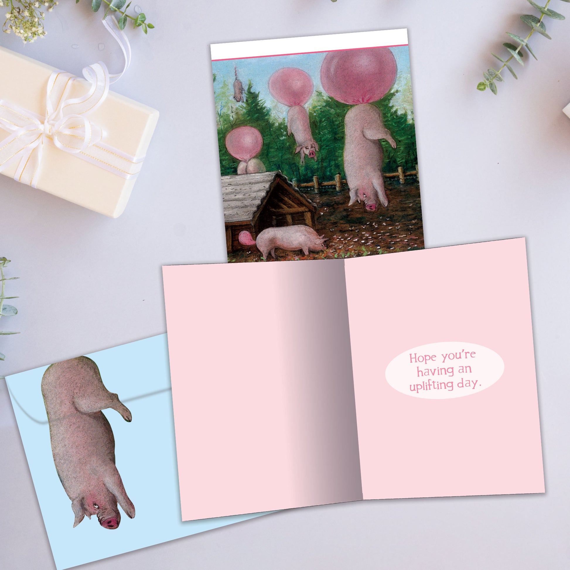 Front and inside view of a Birthday greeting card showcasing "Why you never feed pigs bubble gum," with a matching envelope.
