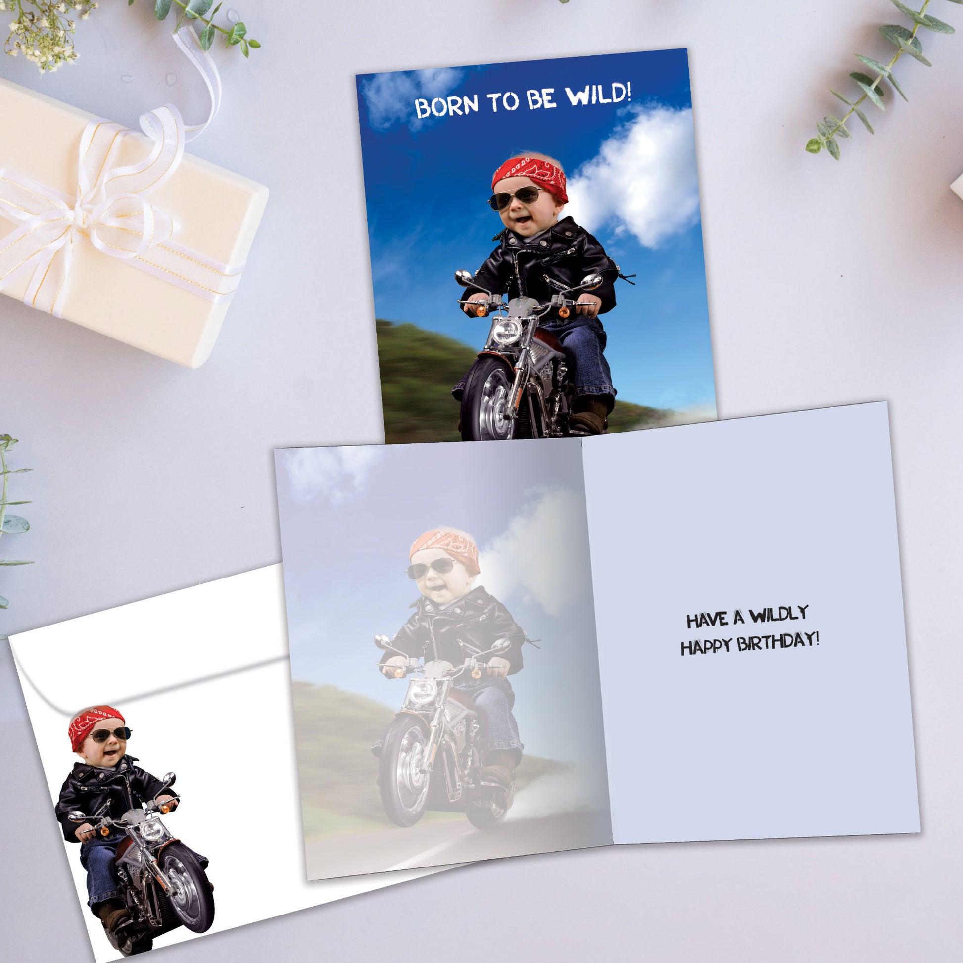 Front and inside view of a Birthday greeting card showcasing a baby on a motorcycle with the words "Born to be wild!" with a matching envelope.